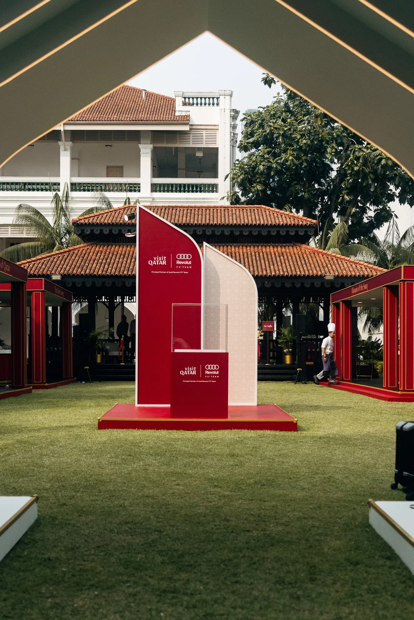 Red event installation displayed in an outdoor garden area.