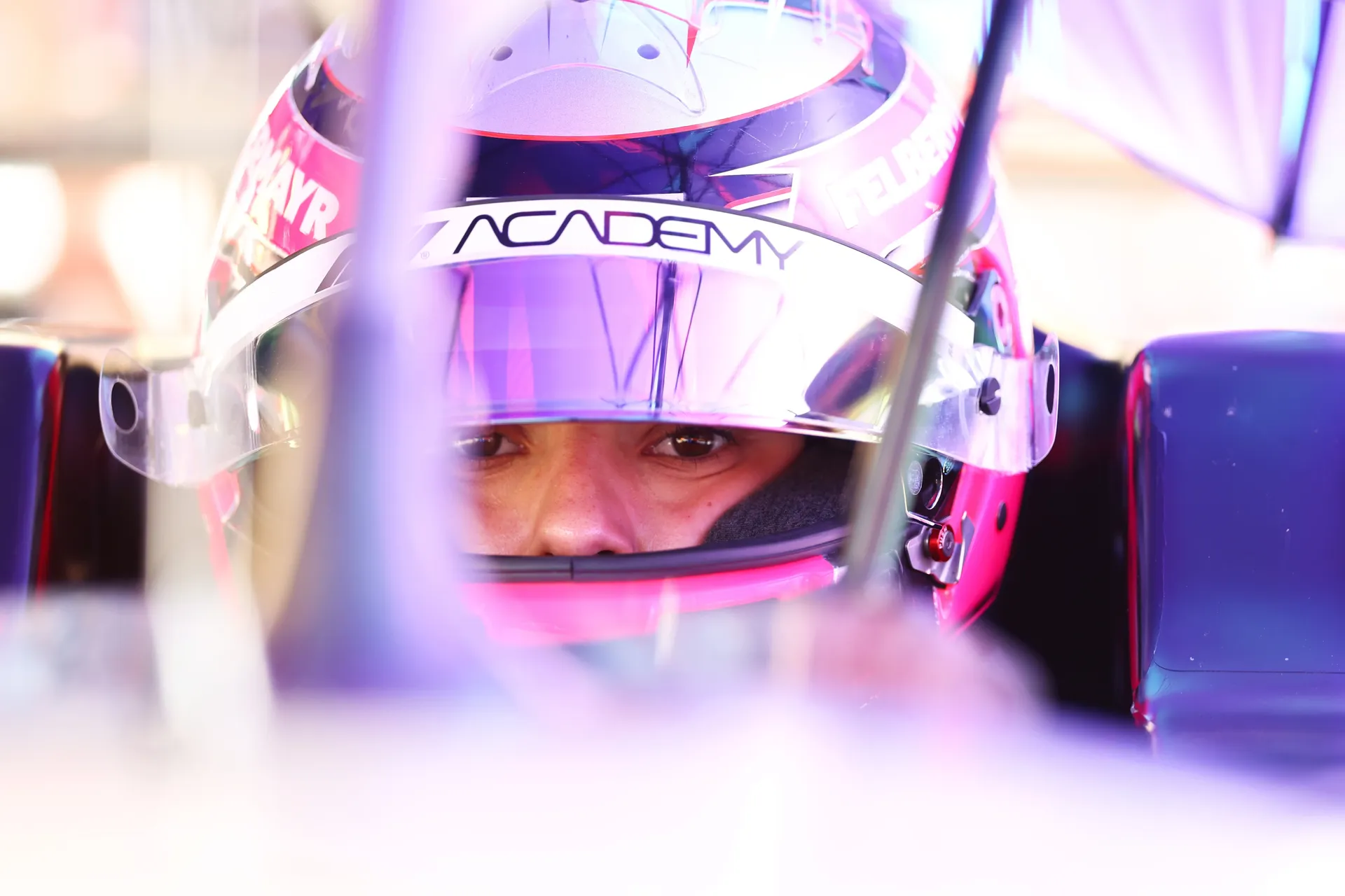 Emma Felbermayr sits focused in the cockpit with her helmet on, eyes forward, preparing for an F1 Academy session with Audi Revolut F1® Team at Silverstone.