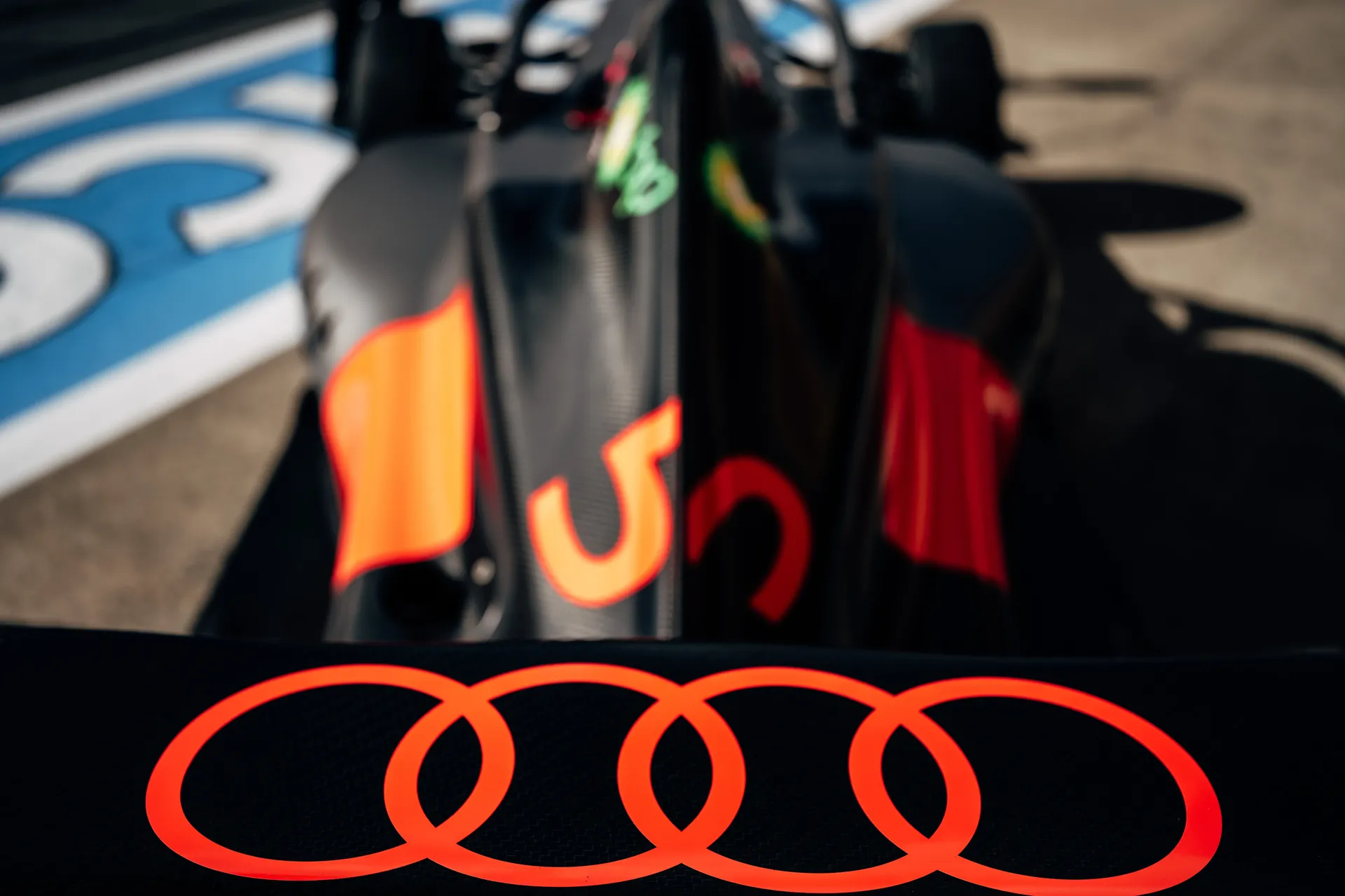 Close-up of the rear bodywork of an Audi Revolut F1® Team car showing the illuminated Audi rings and part of the number 5 under sunlight.