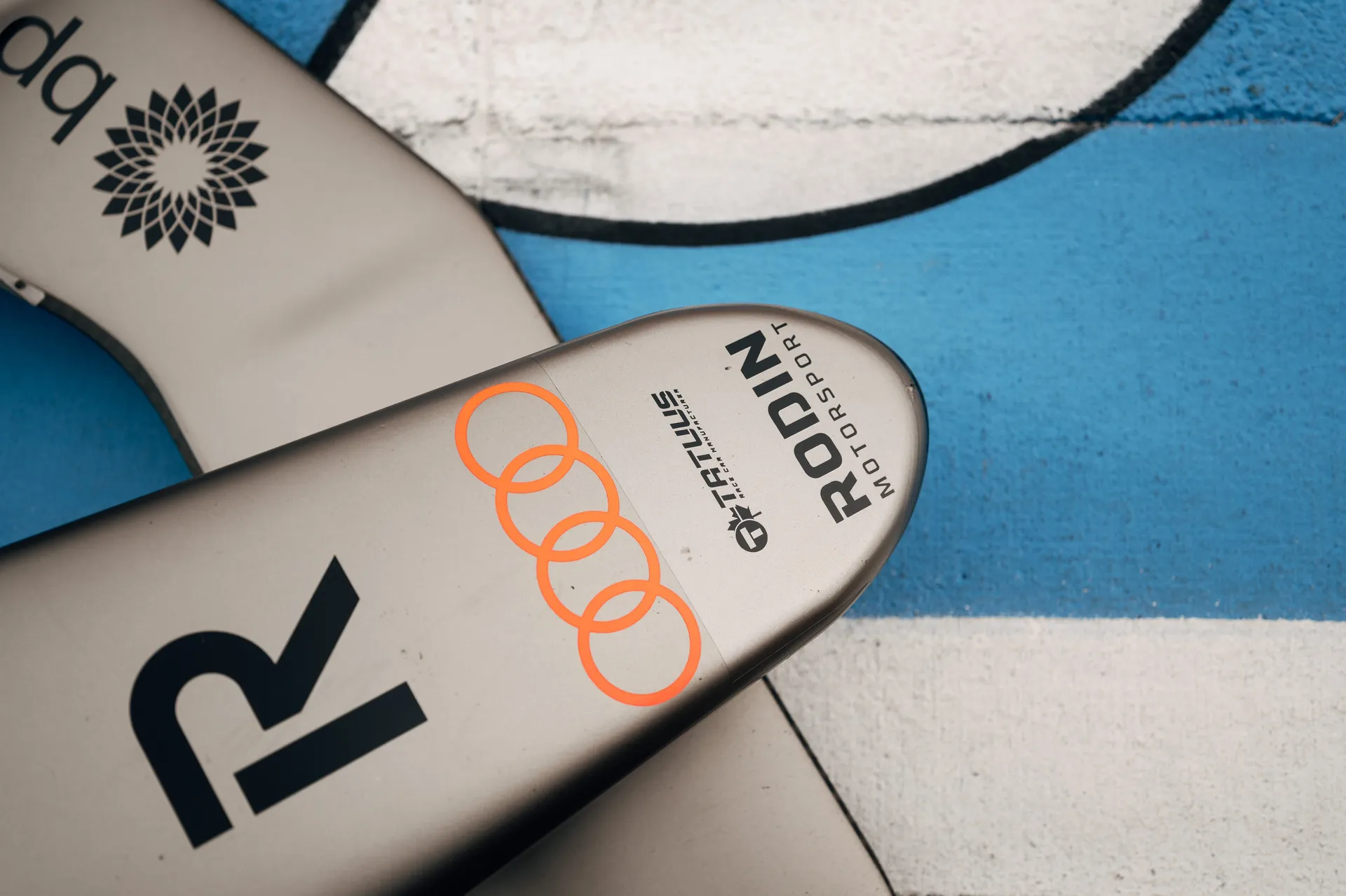 Detail shot of the nose section of an Audi Revolut F1® Team F1 Academy car featuring Audi rings and Rodin Motorsport branding against painted track surface.