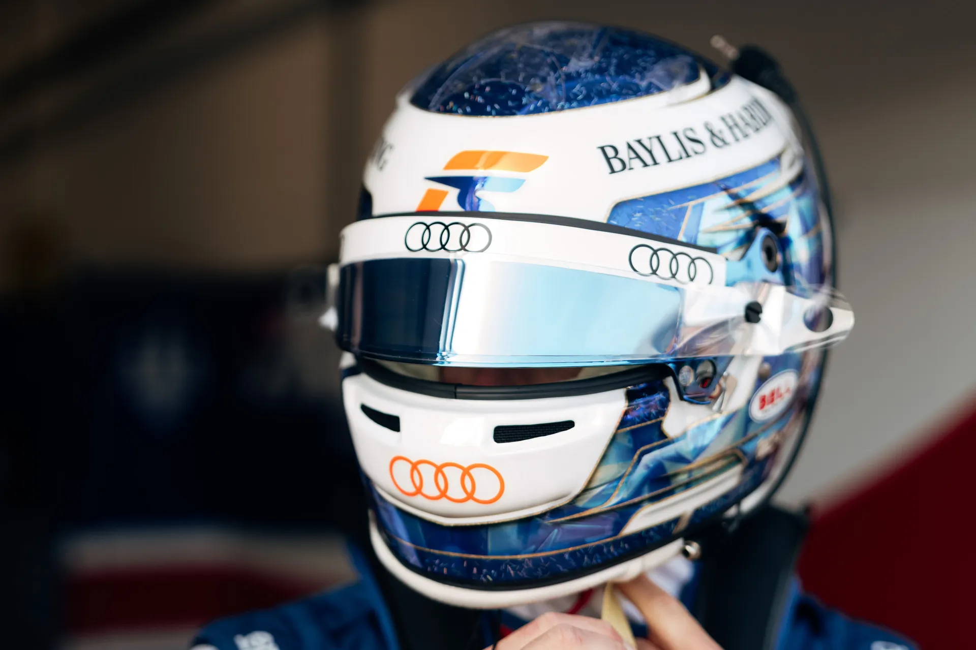 Close-up of Freddie Slater fastening his helmet, featuring Audi branding and reflective visor, moments before heading out on track in F3 at Silverstone.