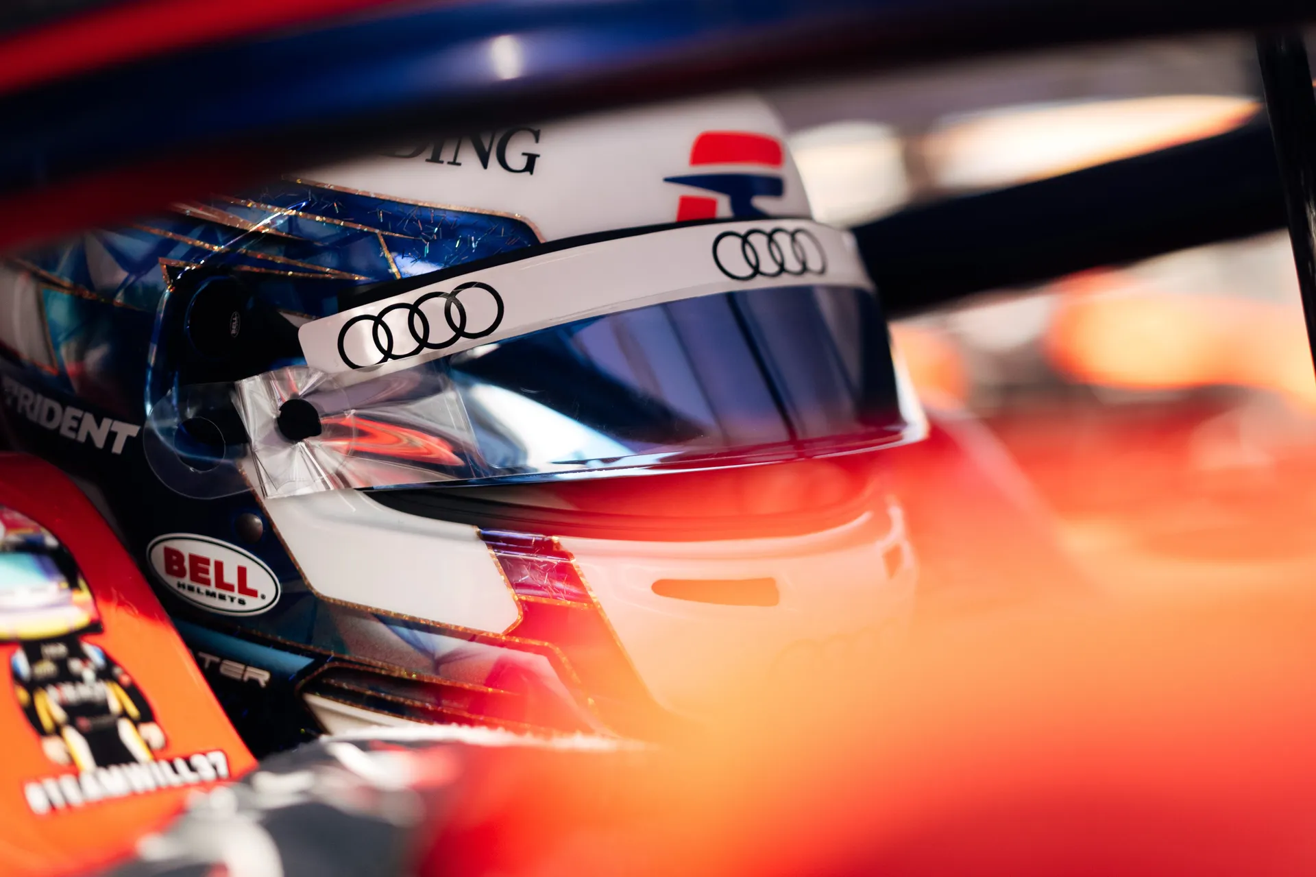 Detail shot of Freddie Slater’s helmet inside the cockpit, framed by the halo, highlighting Audi branding and visor reflection.