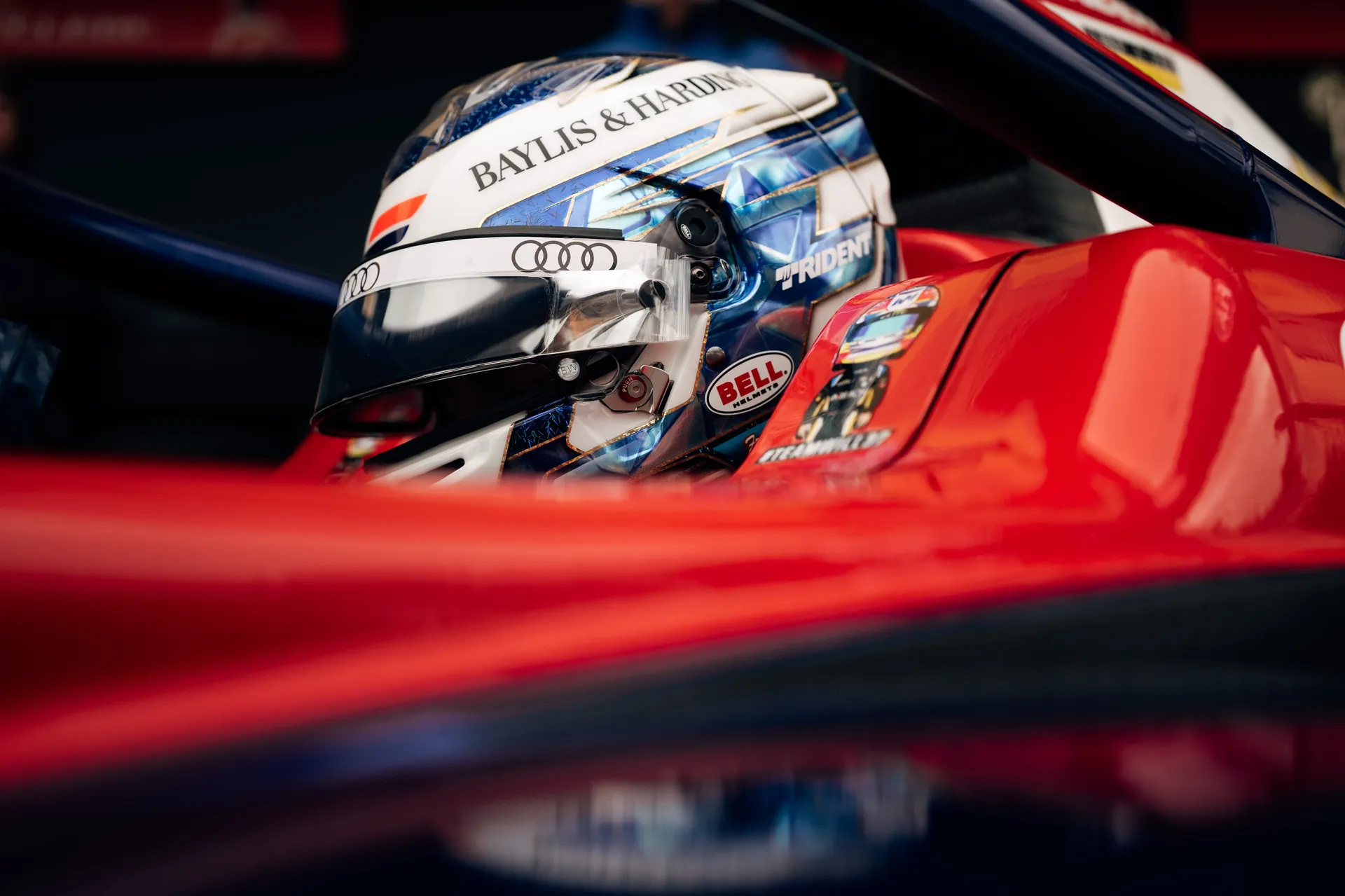 Close-up of Freddie Slater’s helmet inside the cockpit of a Trident Formula 3 car, with Audi branding visible on the visor strip.