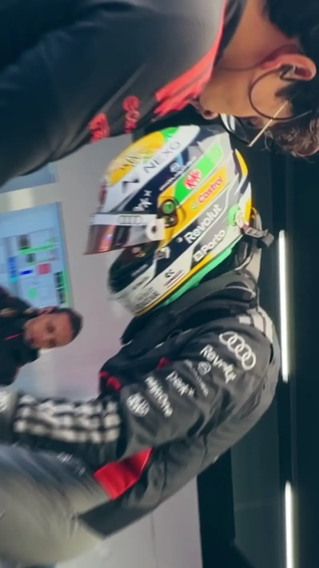 Gabriel Bortoleto of the Audi Revolut F1® Team jumps into the cockpit of the Audi R26 duringfor the sprint qualifying in the Silverstone garage, surrounded by mechanics preparing the car for track action.