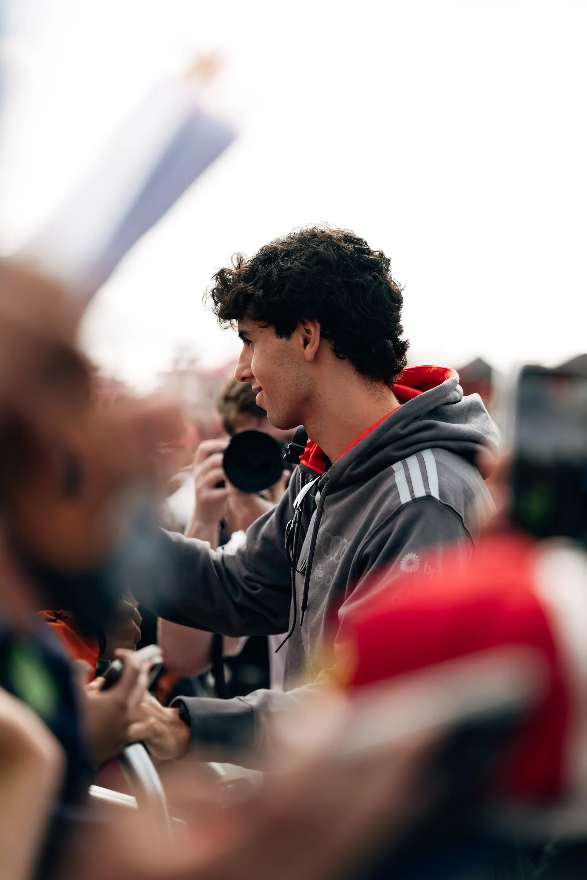 Gabriel Bortoleto arrives in the paddock on Friday at Silverstone, wearing Audi Revolut F1® Team kit and carrying a backpack, making his way through the crowd.