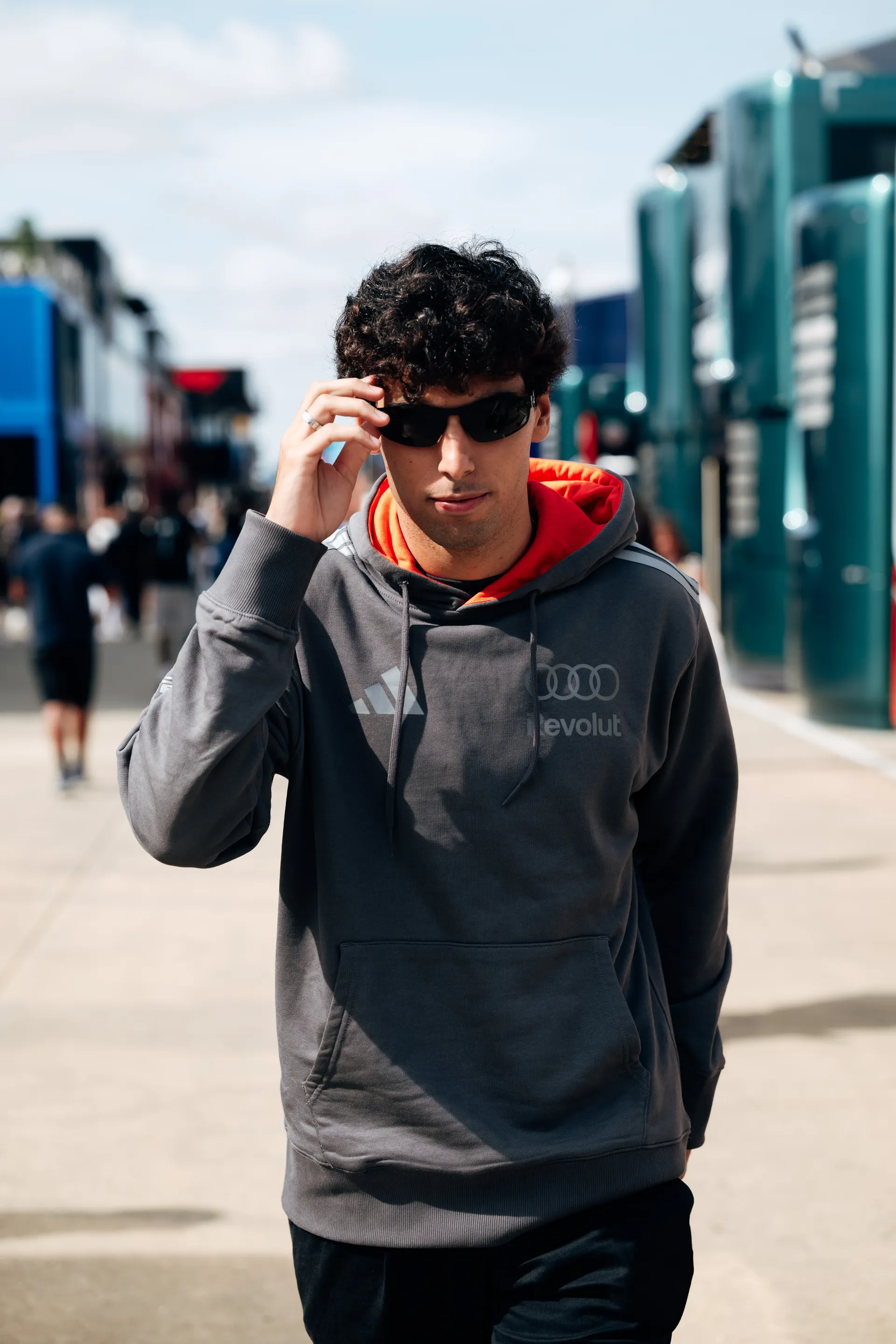 Gabriel Bortoleto arrives at Silverstone on Friday wearing sunglasses, walking through the paddock in Audi Revolut F1® Team kit.