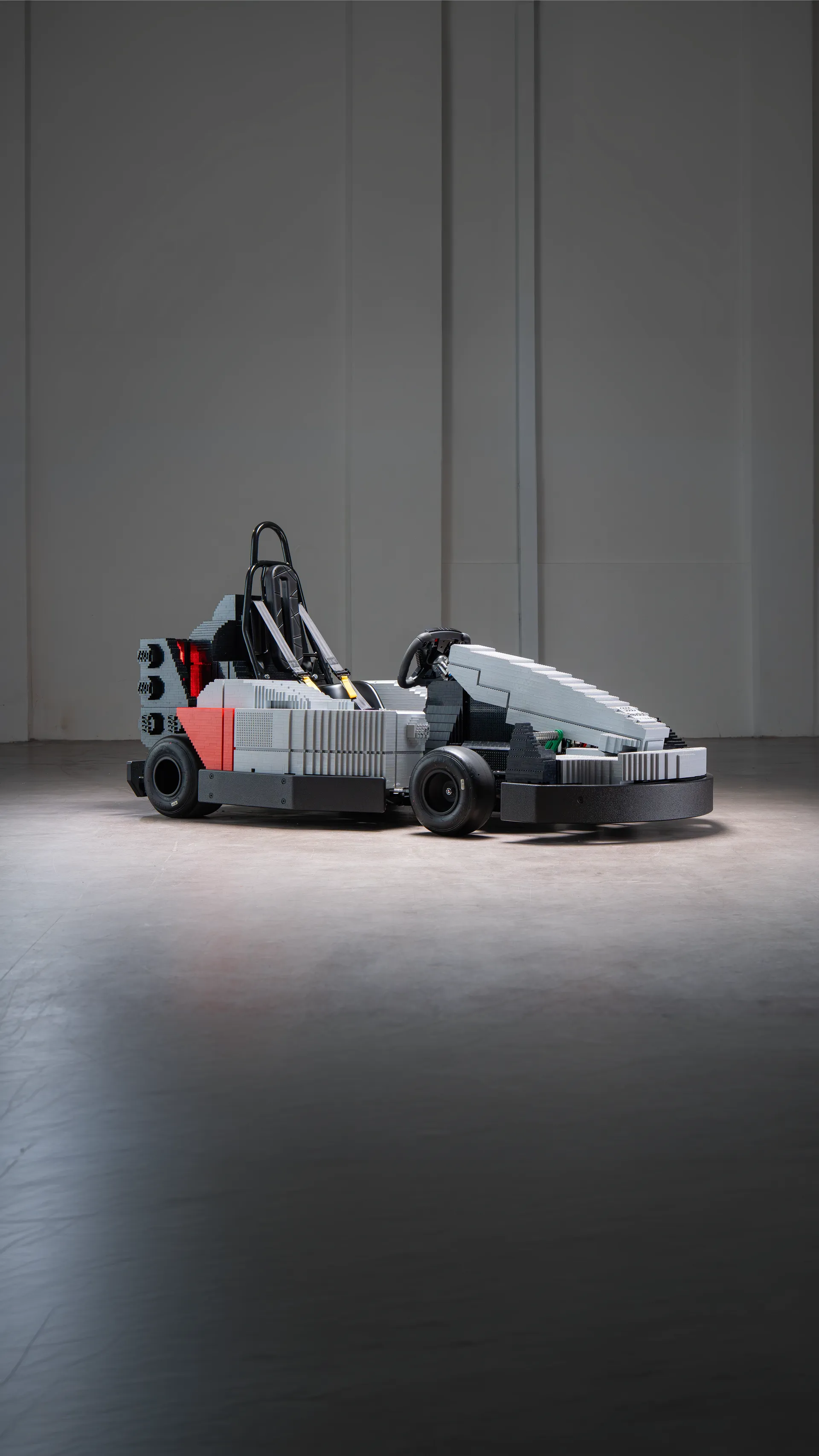 LEGO-built kart inspired by Audi Revolut F1® Team design centred in a large studio space, highlighting scale and silhouette.