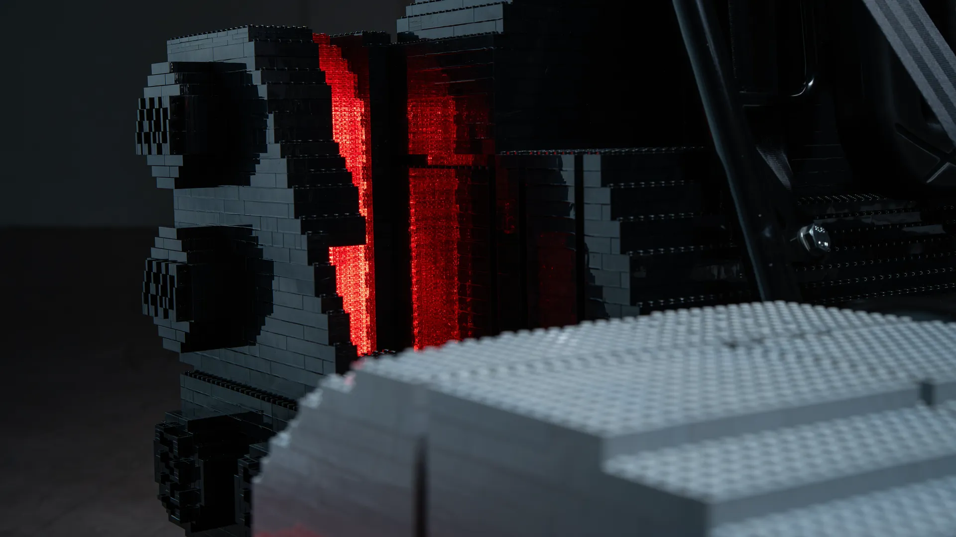 Close-up of the rear section of the LEGO-built kart inspired by Audi Revolut F1® Team, with illuminated red brick elements resembling a rear light.