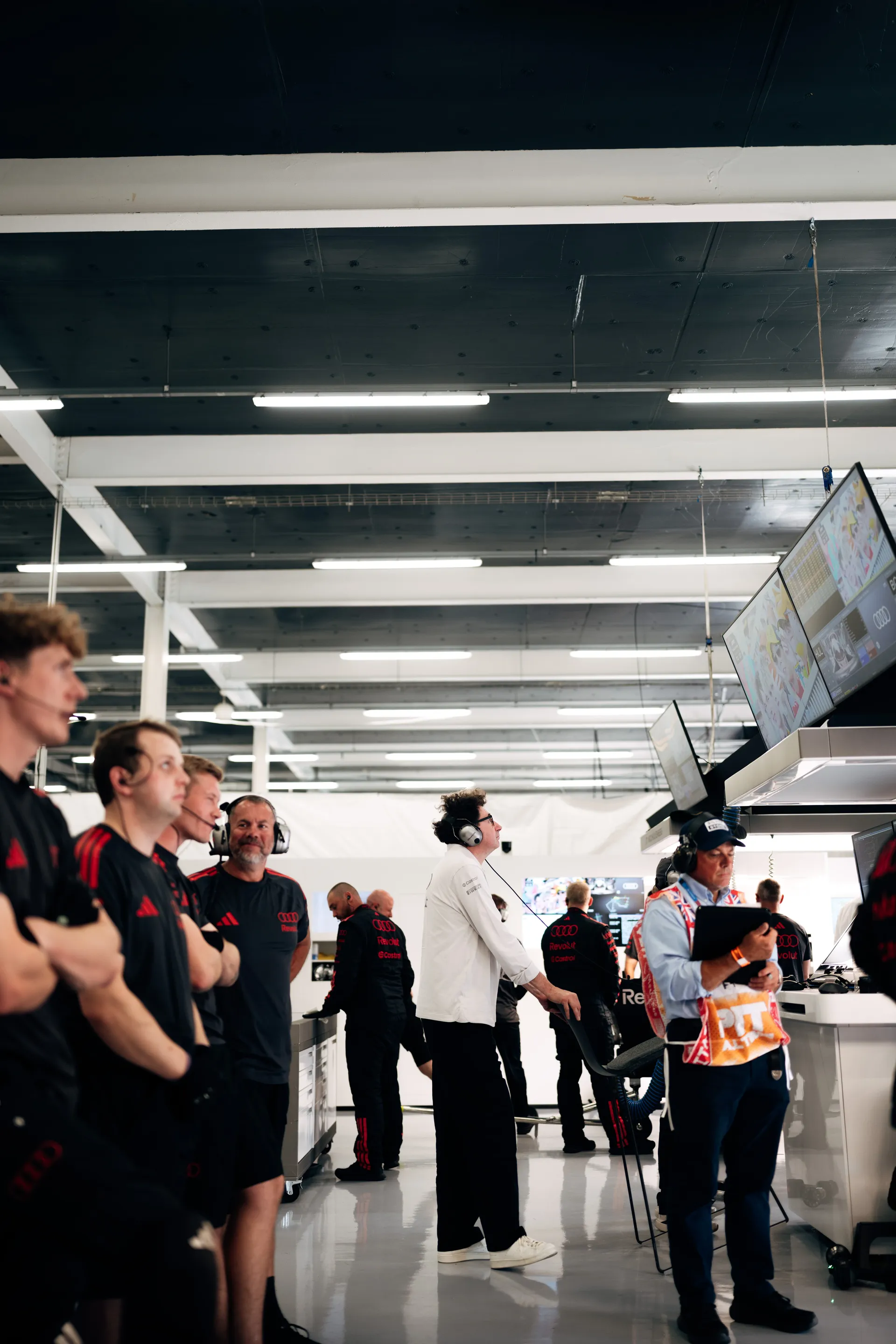 Audi Revolut F1® Team crew and Mattia Binotto monitor live telemetry and timing screens inside the garage during the Qualifying session at Silverstone.