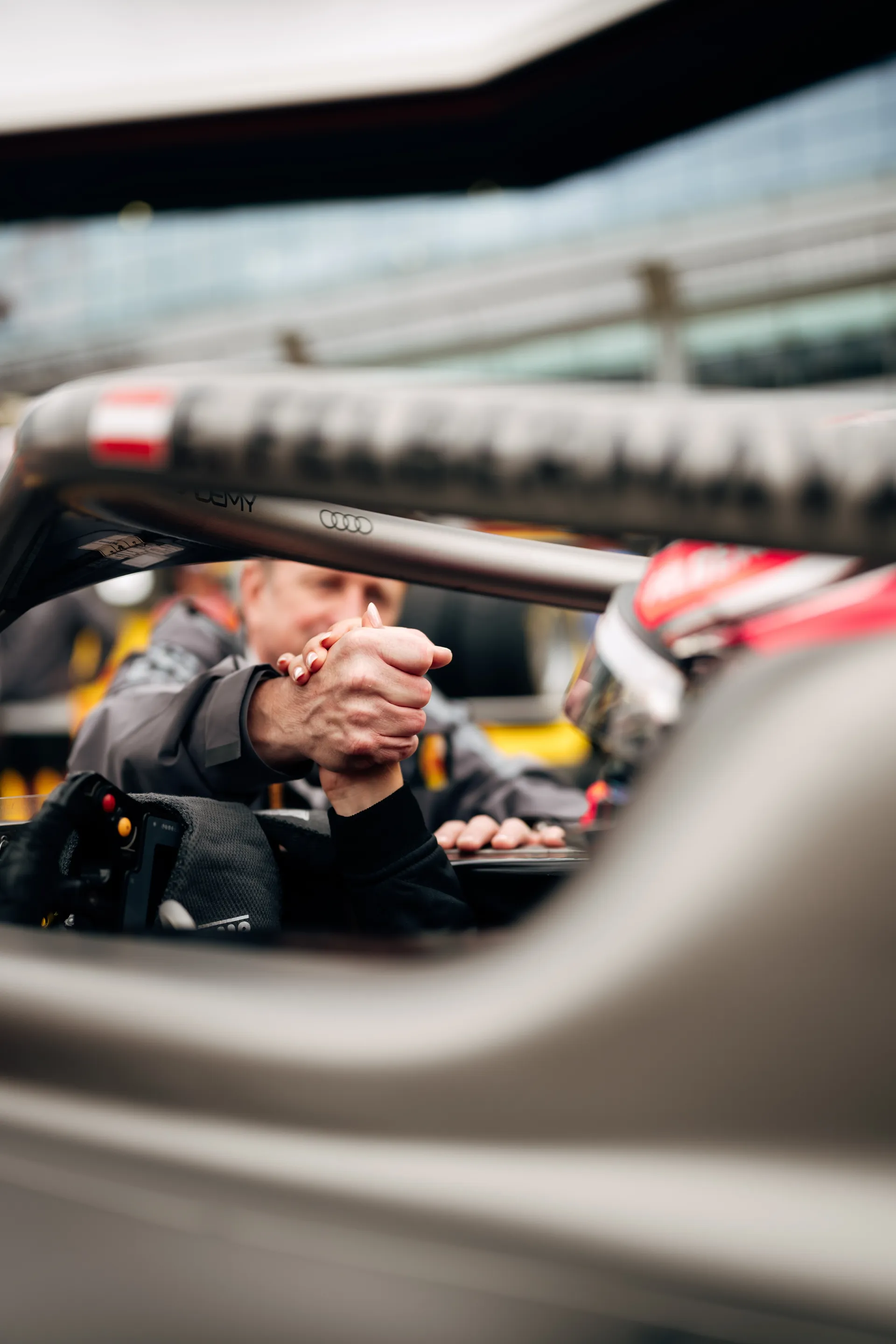 Allan McNish shaking hands with Emma Felbermayr inside the cockpit of an Audi Revolut F1® Team car.