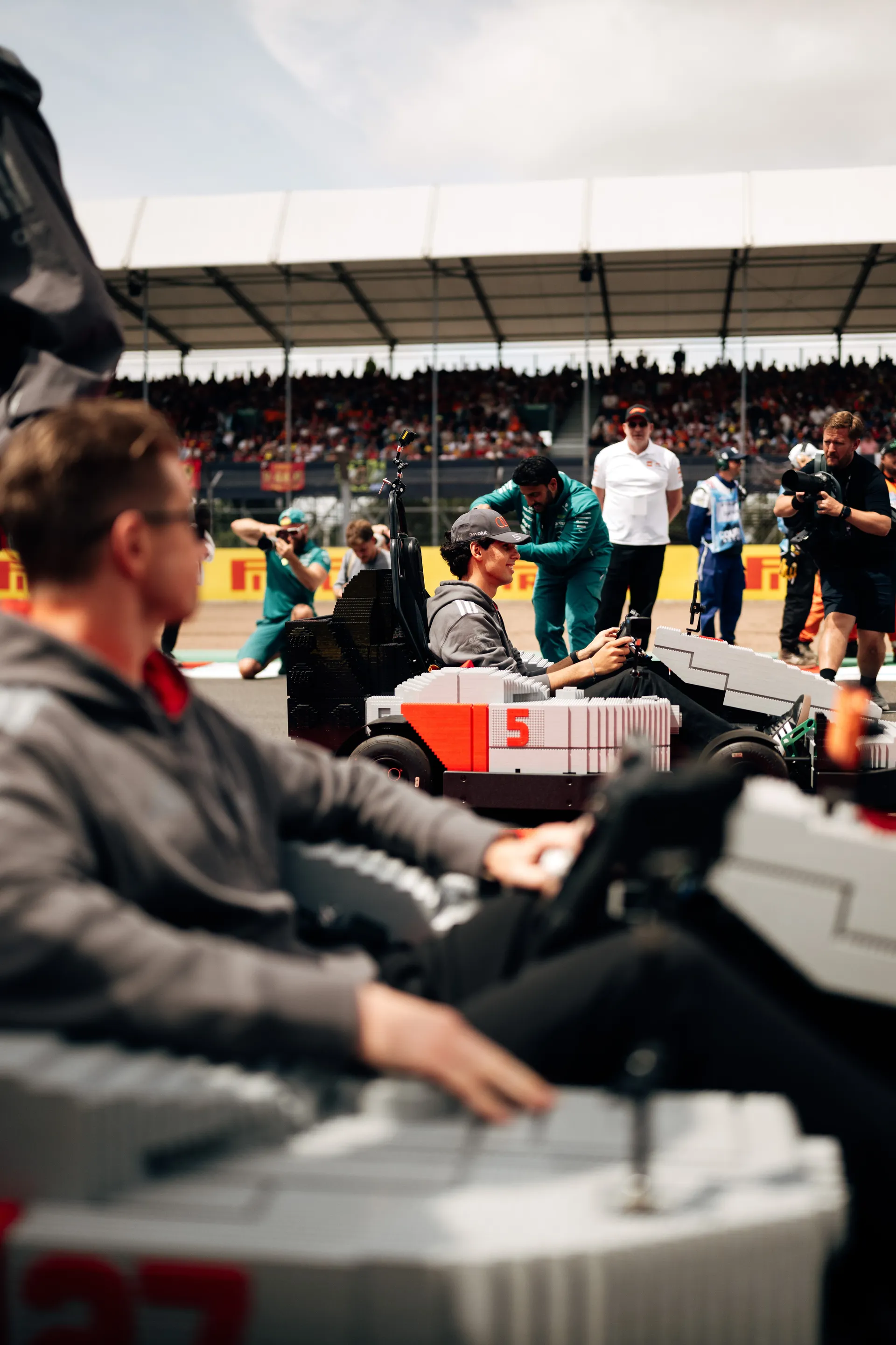 Wide shot of drivers including Gabriel Bortoleto driving LEGO® Audi R26 karts during the Drivers’ Parade.