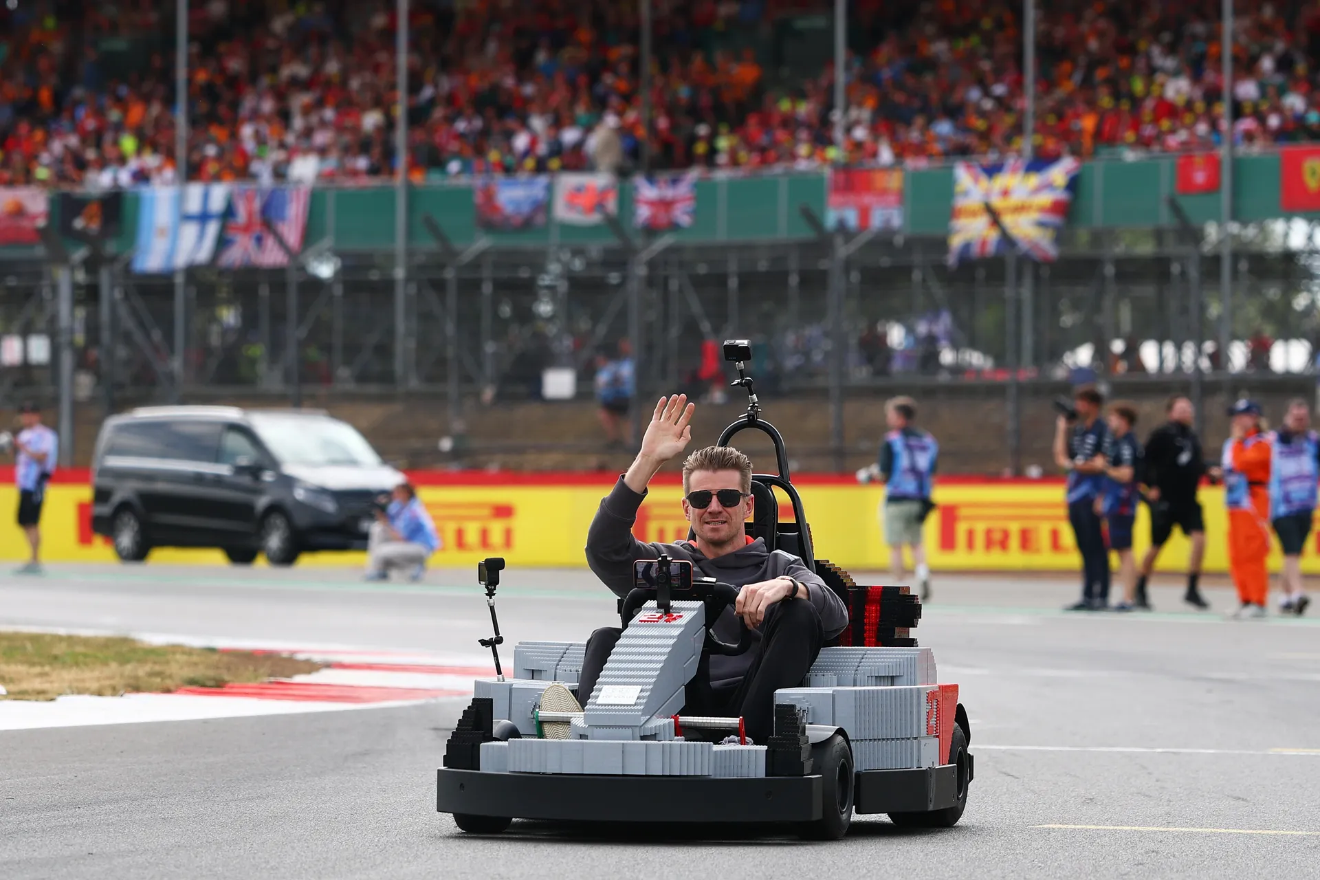 Nico Hulkenberg driving an Audi R26 LEGO kart and waving to the crowd during the Silverstone drivers’ parade.