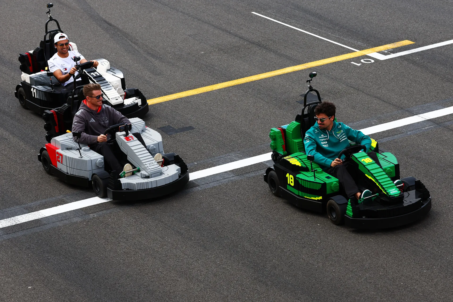 Nico Hulkenberg and Gabriel Bortoleto driving Audi R26 LEGO karts alongside other drivers on the Silverstone grid during the drivers’ parade.