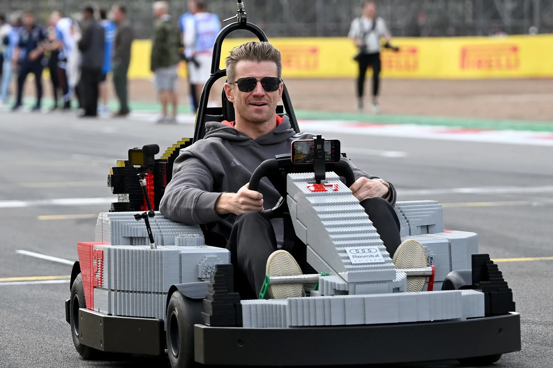 Nico Hulkenberg driving an Audi R26 LEGO kart on track, focused ahead during the Silverstone drivers’ parade.