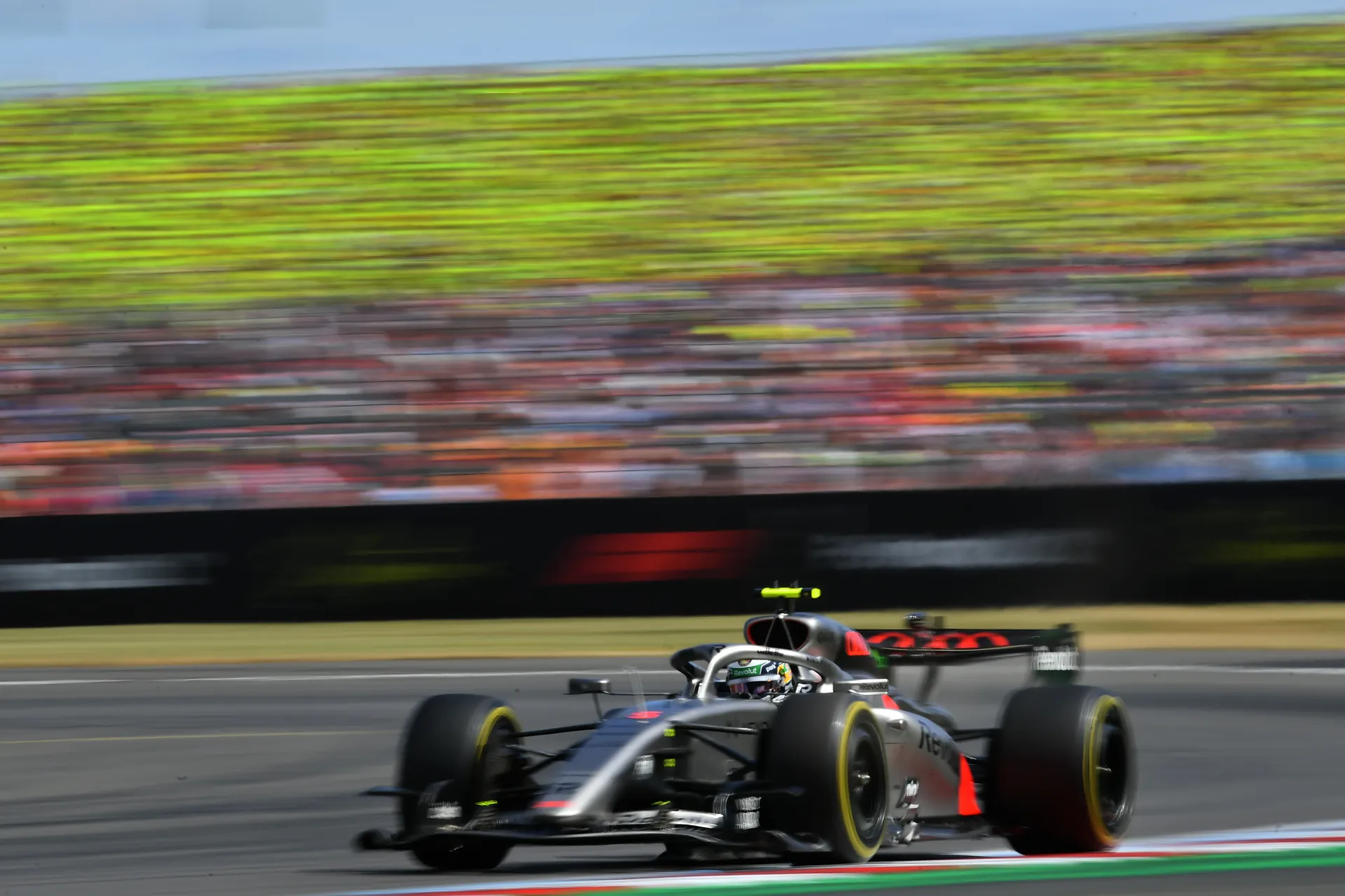 Audi R26 racing at speed along the Silverstone circuit with motion blur emphasising pace.
