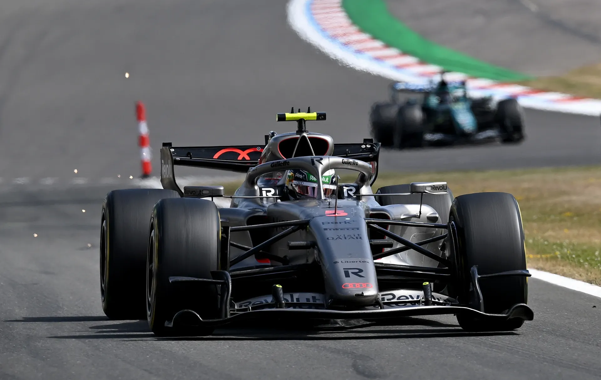 Front view of the Audi R26 racing towards the camera with sparks visible from the track surface.