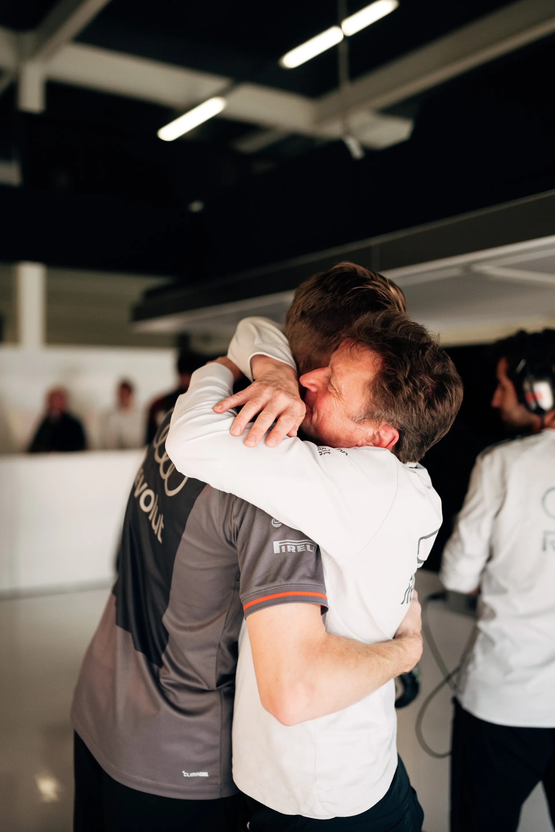 Nico Hulkenberg embraces Allan McNish inside the Audi Revolut F1® Team garage, capturing a moment of trust and team spirit during the Silverstone race weekend.