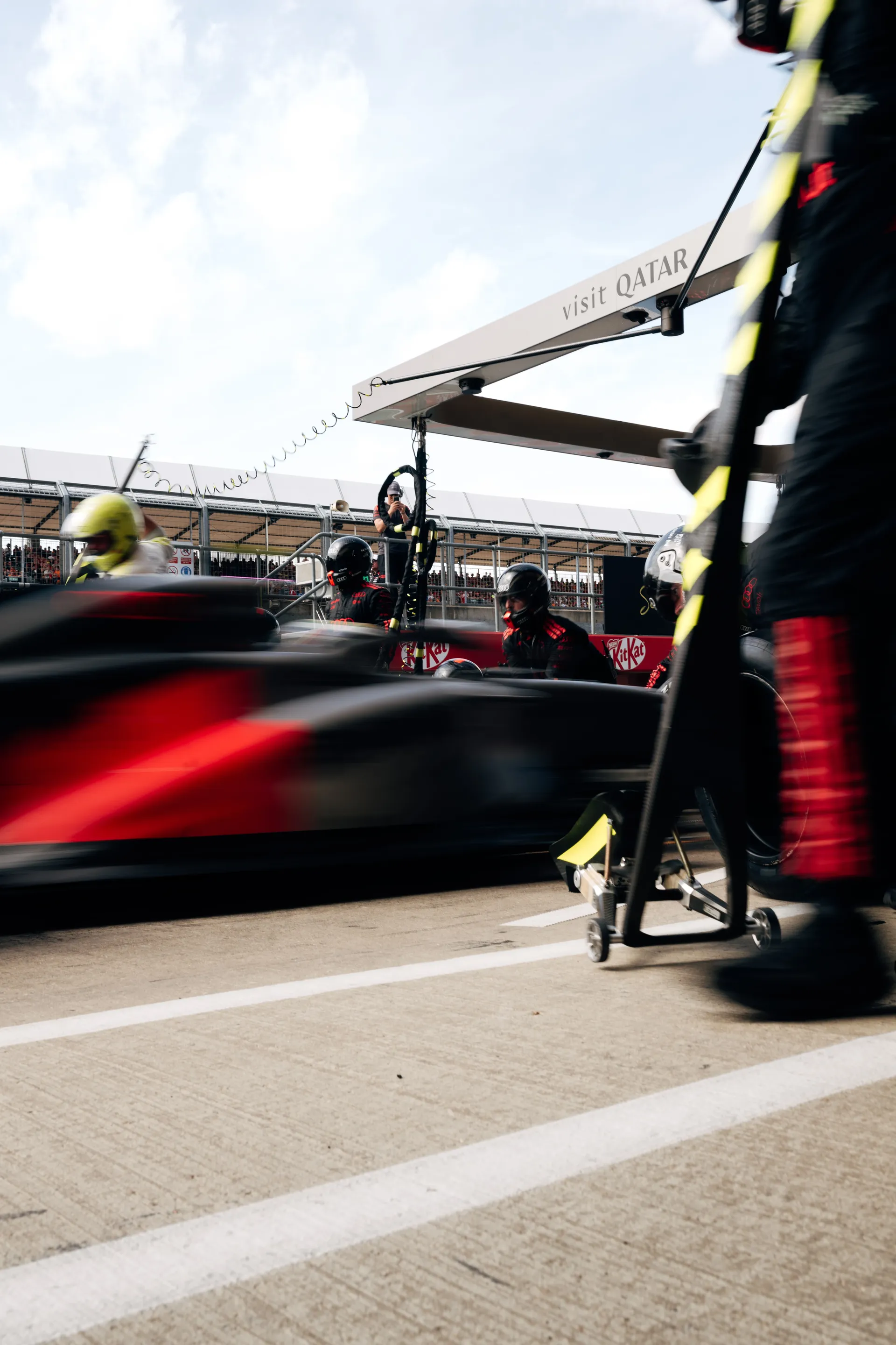 The Audi Revolut F1® Team executes a pit stop as the R26 passes through the pit lane at speed.