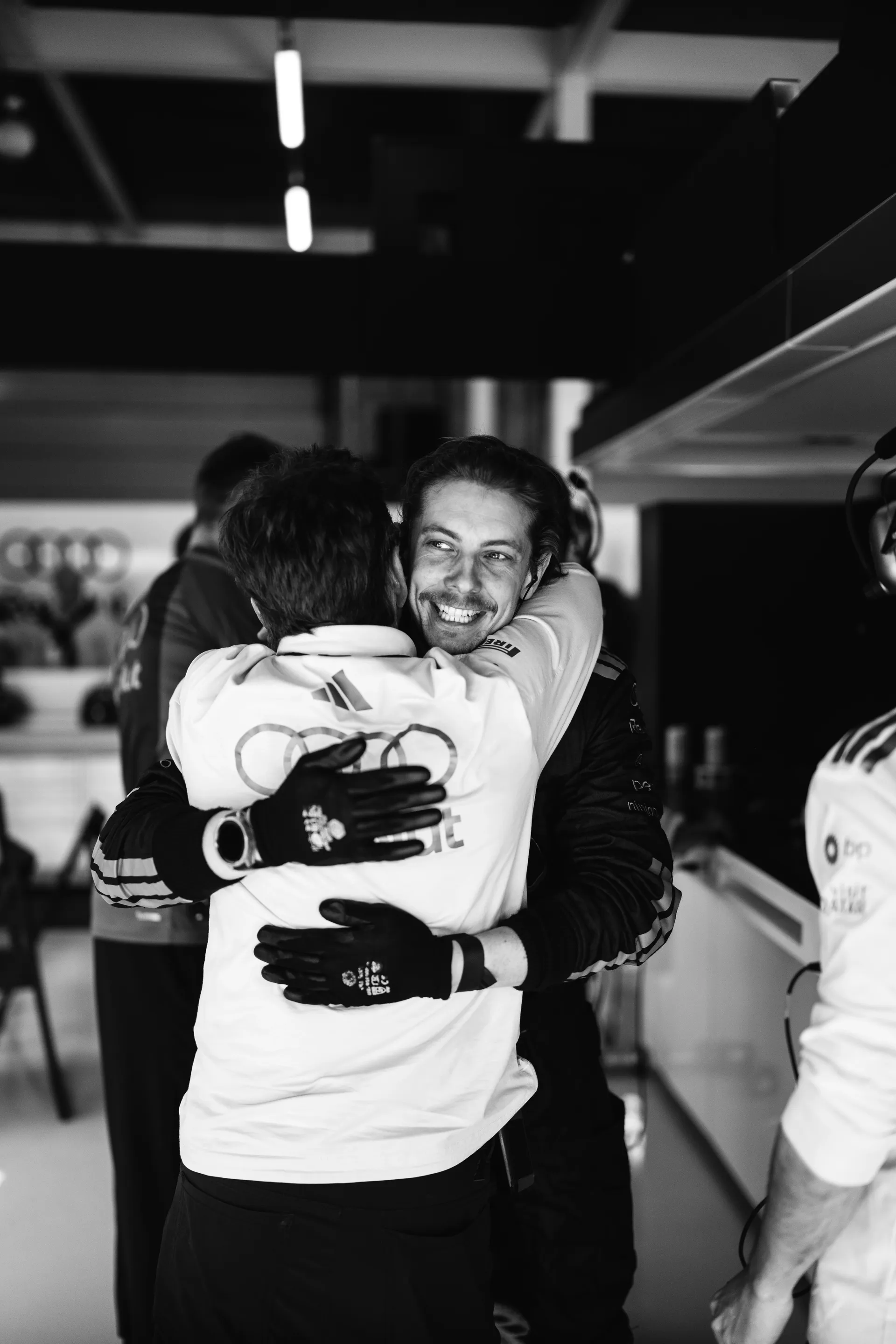 Celebration and smiles while embracing a team member inside the Audi Revolut F1® Team garage.
