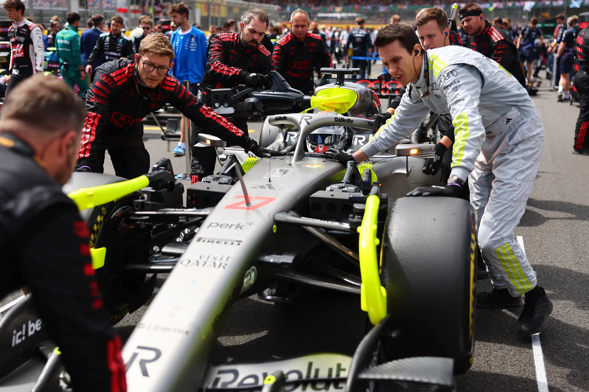 Audi Revolut F1® Team crew pushing a car on the grid with Nico Hulkenberg seated in the cockpit during pre-session positioning.