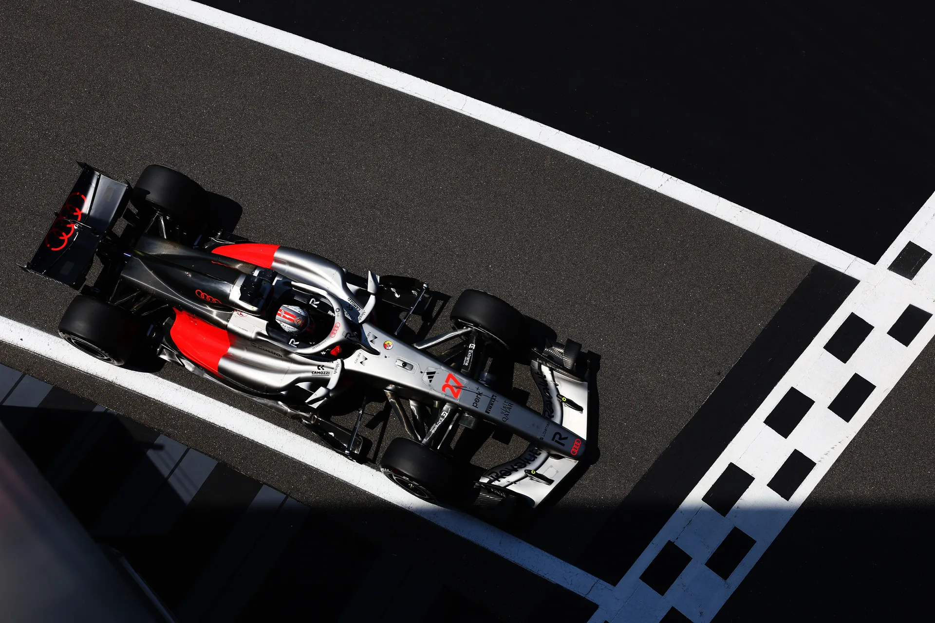 Top-down view of the Audi R26 crossing the start-finish line on track at Silverstone.