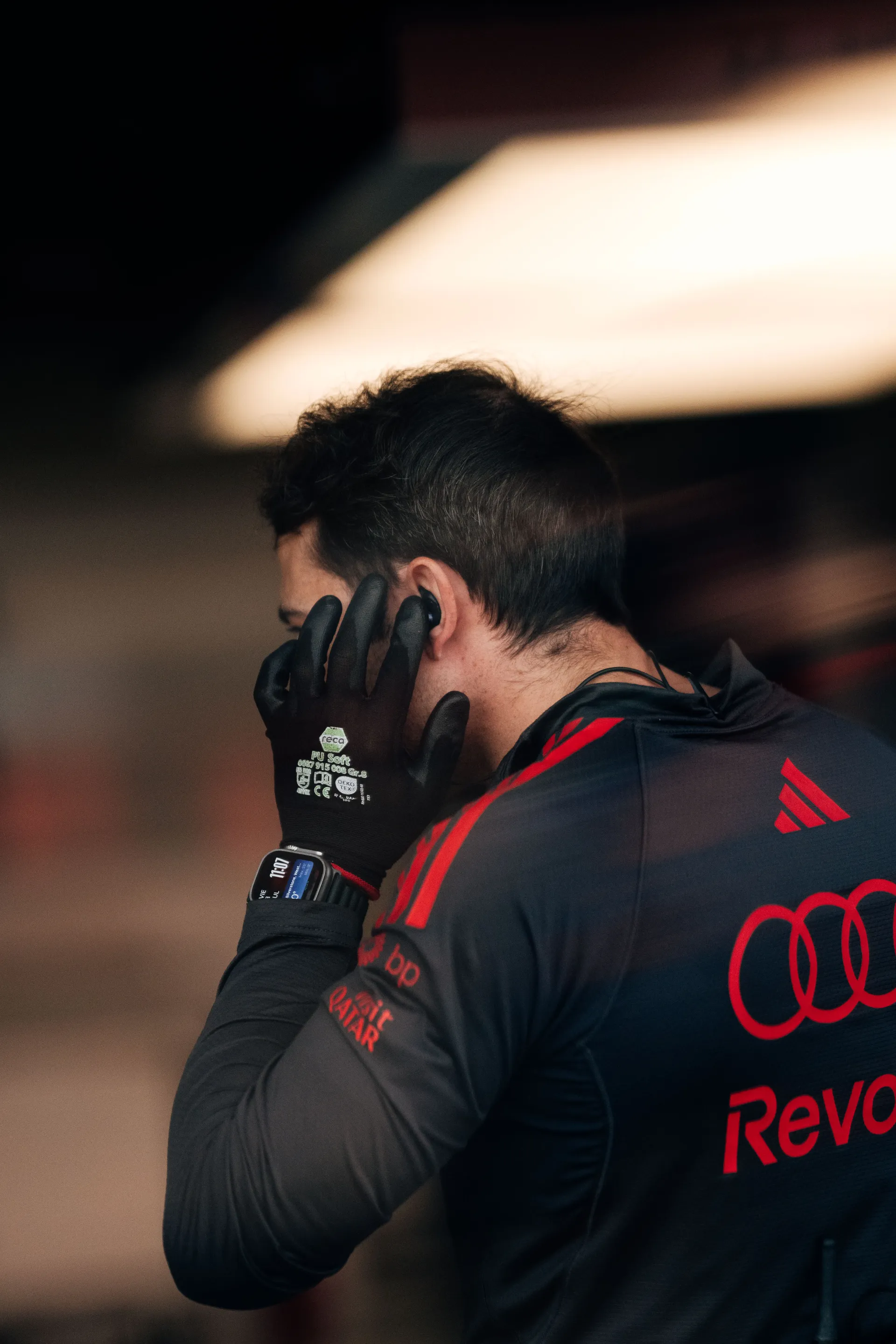 A mechanic from the Audi Revolut F1® Team adjusts an earpiece while preparing for on-track action.