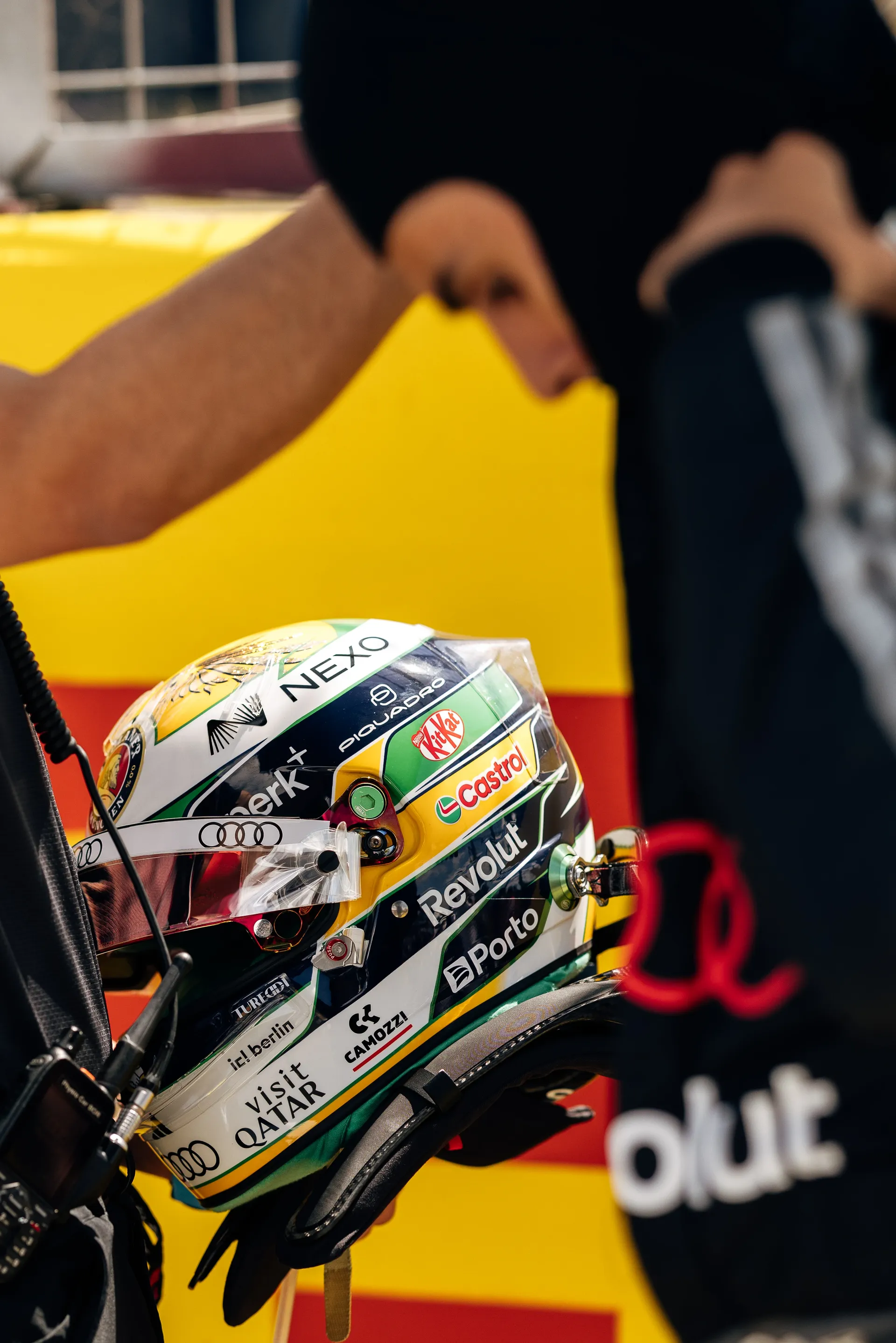 A close-up of Gabriel Bortoleto’s helmet in Brazilian colours as a team member makes final adjustments before the Sprint race.