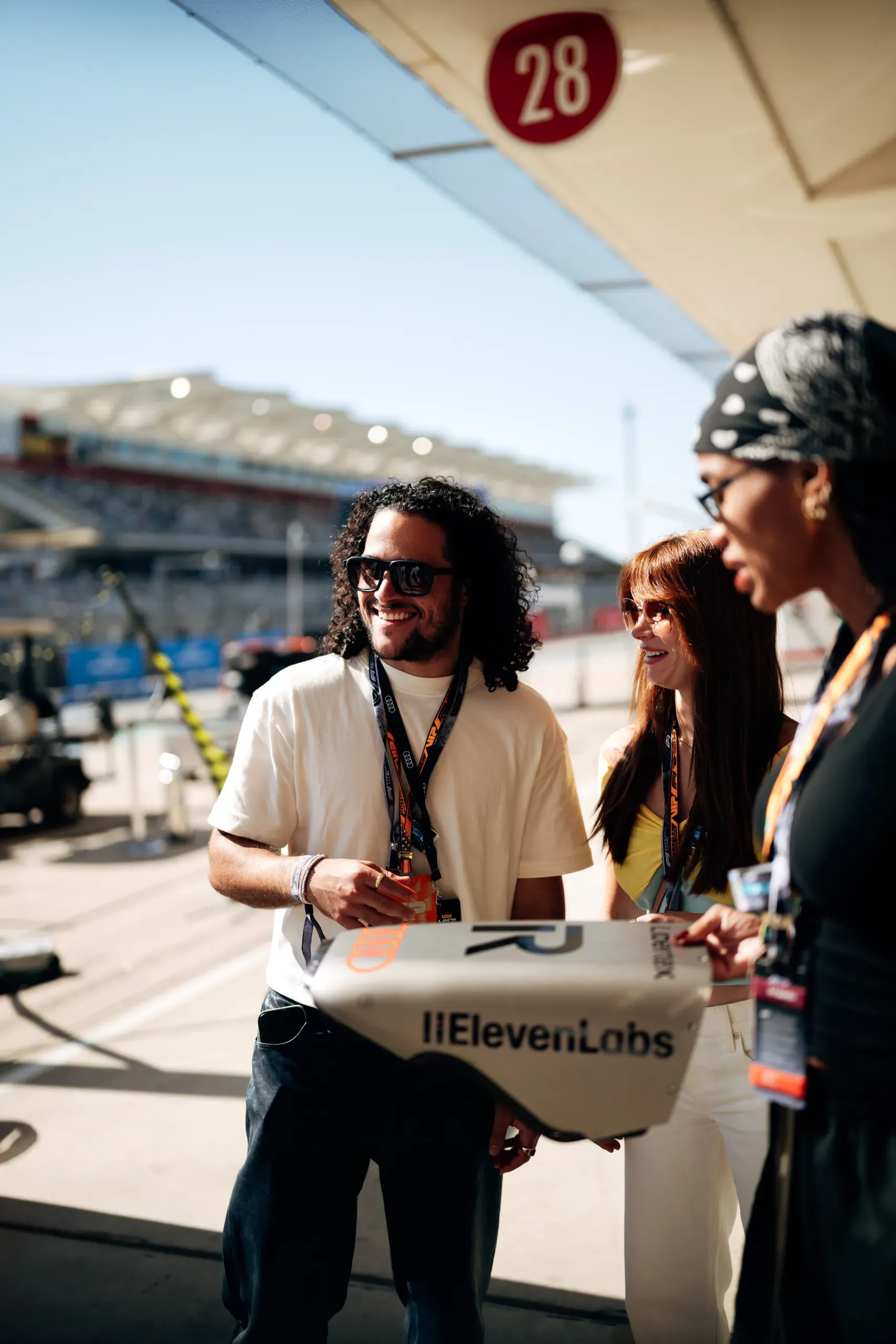 Guests hold an Audi Revolut F1® Team bodywork panel in the pit lane at the United States Grand Prix