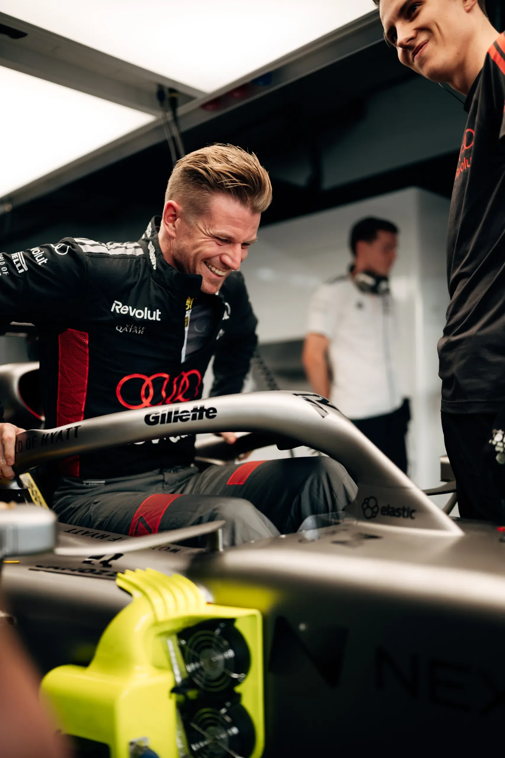 Audi Revolut F1® Team driver Nico Hulkenberg laughing while climbing into the Audi R26 in the garage