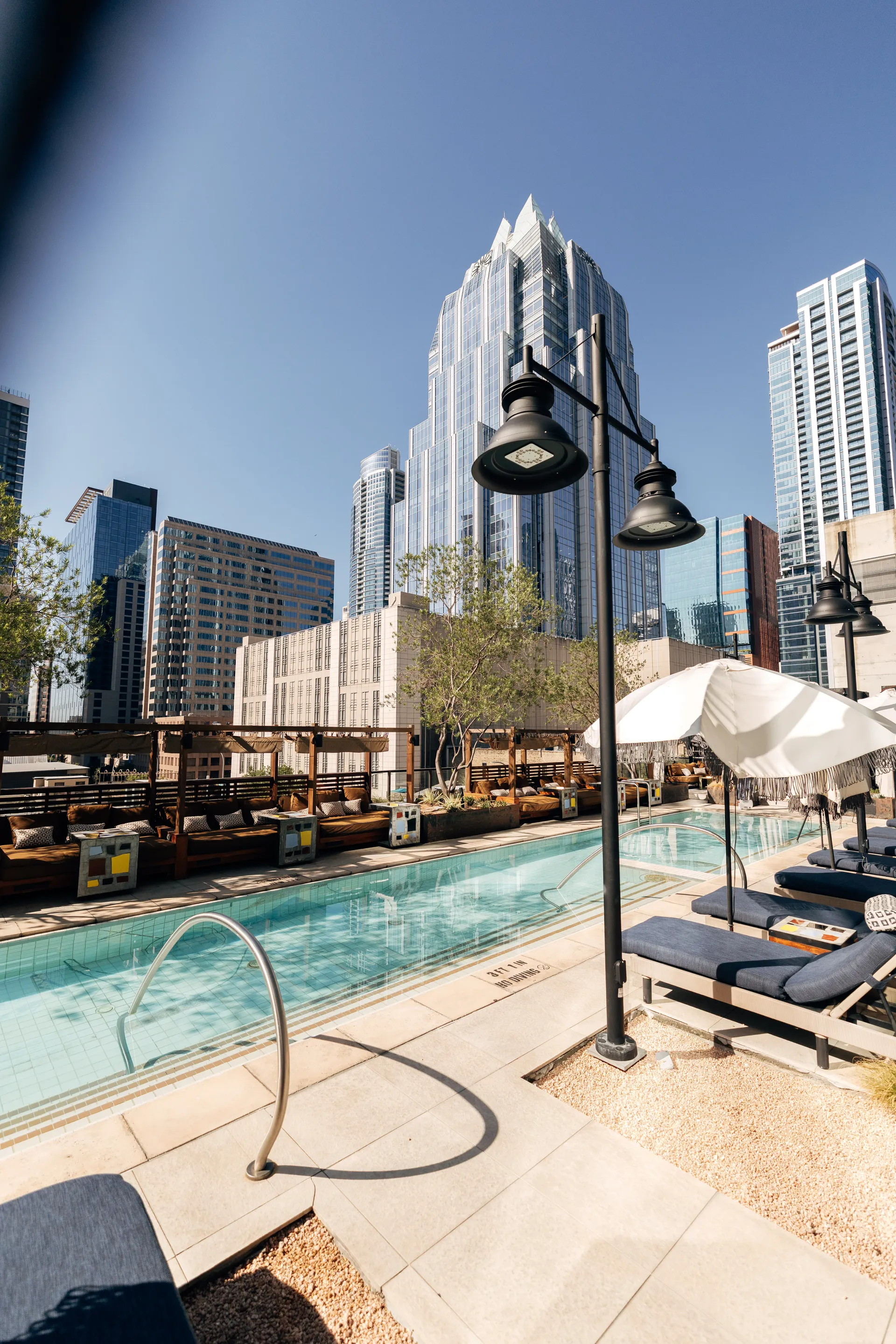 Rooftop pool with sun loungers and the Frost Bank Tower in the background in downtown Austin