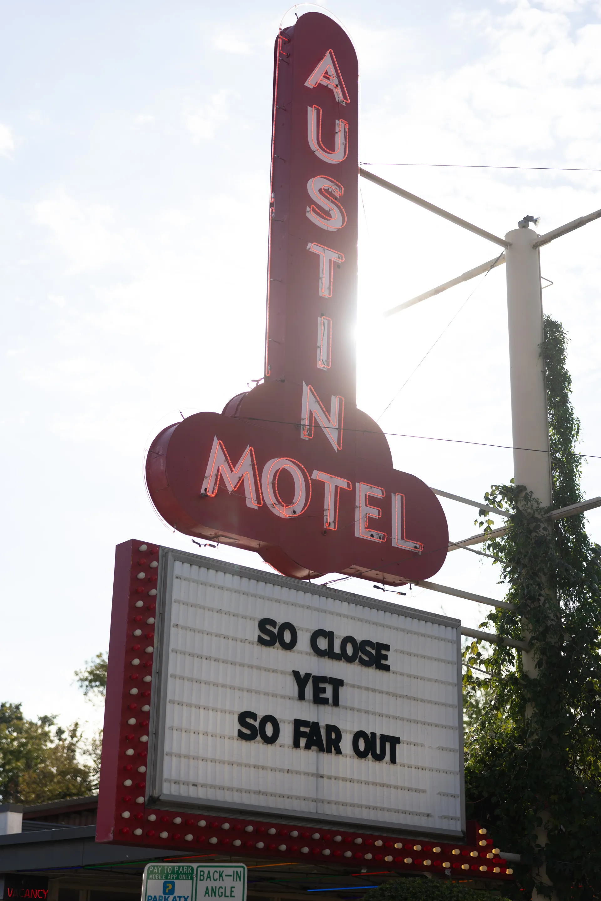 Neon sign of the Austin Motel with a marquee reading So Close Yet So Far Out, United States Grand Prix