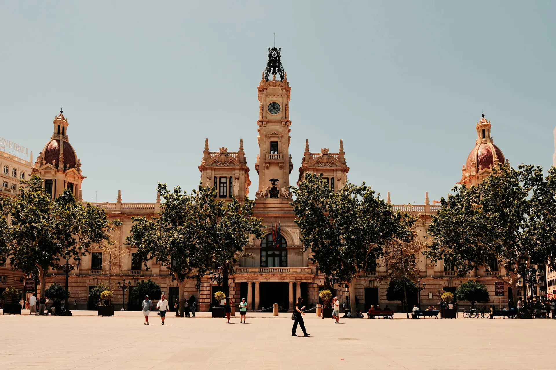 Valencia city hall on the Plaça de l'Ajuntament with passers-by crossing the square