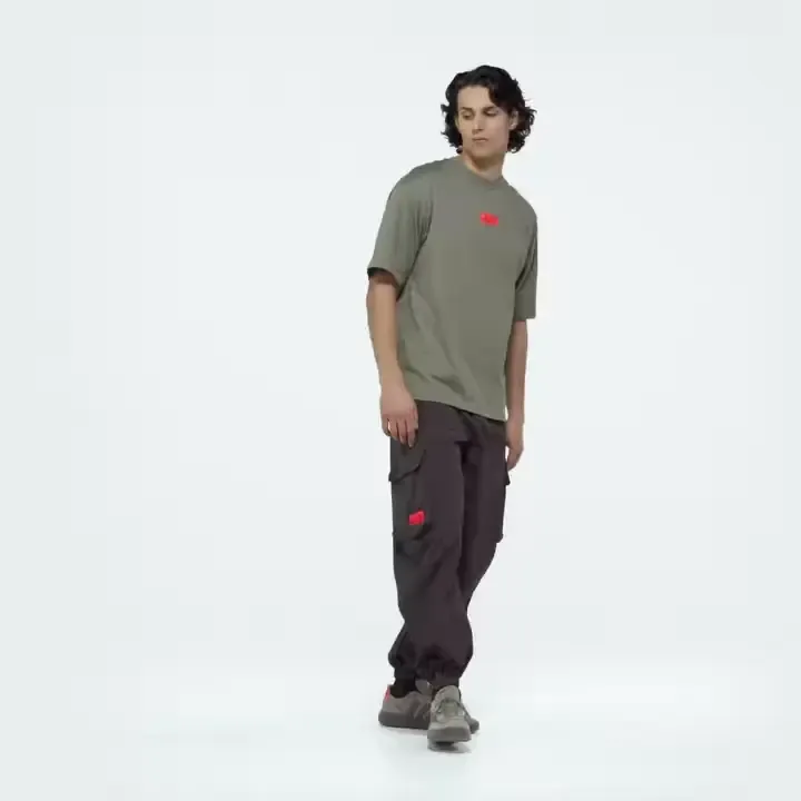 Young male model wearing adidas x Audi Revolut F1® Team Fanwear collection elevated woven pants in the Studio
