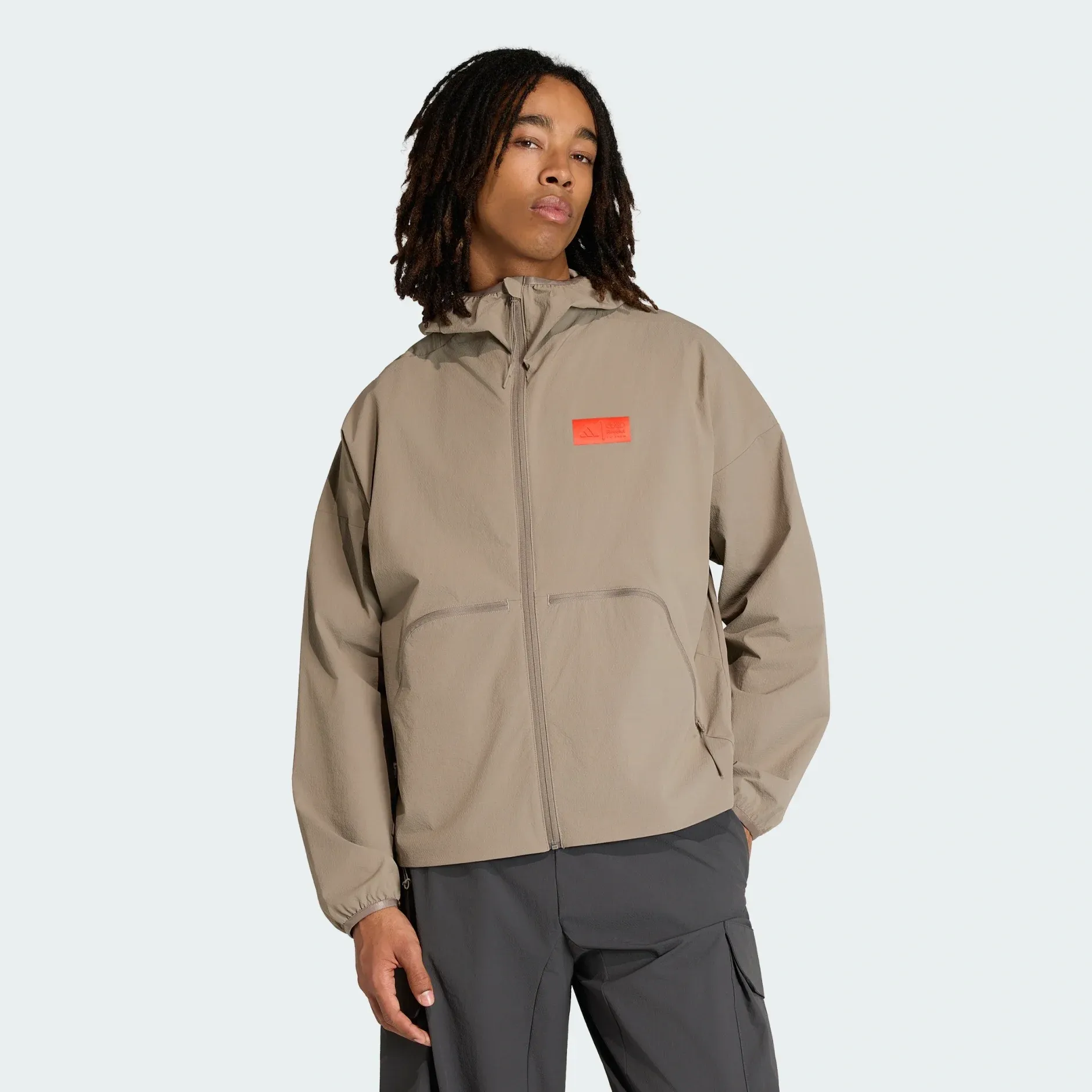 Young male model wearing adidas x Audi Revolut F1® Team fanwear elevated woven jacket in the Studio