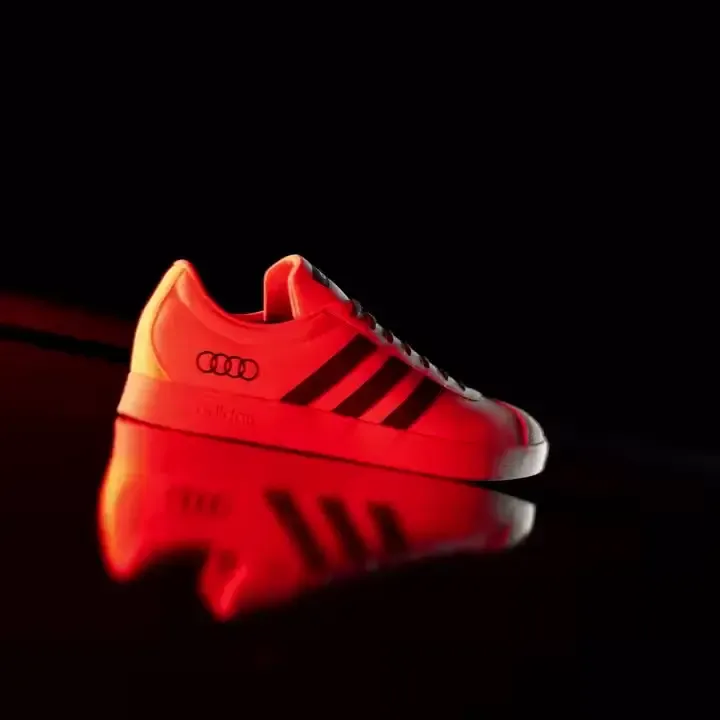 Close up of the adidas x Audi Revolut F1® Team fanwear collection VL COURT shoes in dramatic red light in the studio