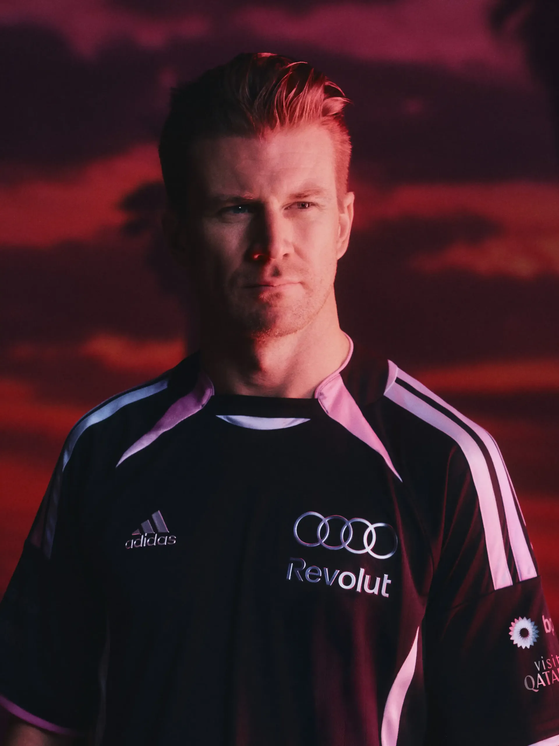 Portrait of Nico Hulkenberg athlete of the Audi Revolut F1® Team wearing teamwear outfit with dramatic red background lighting