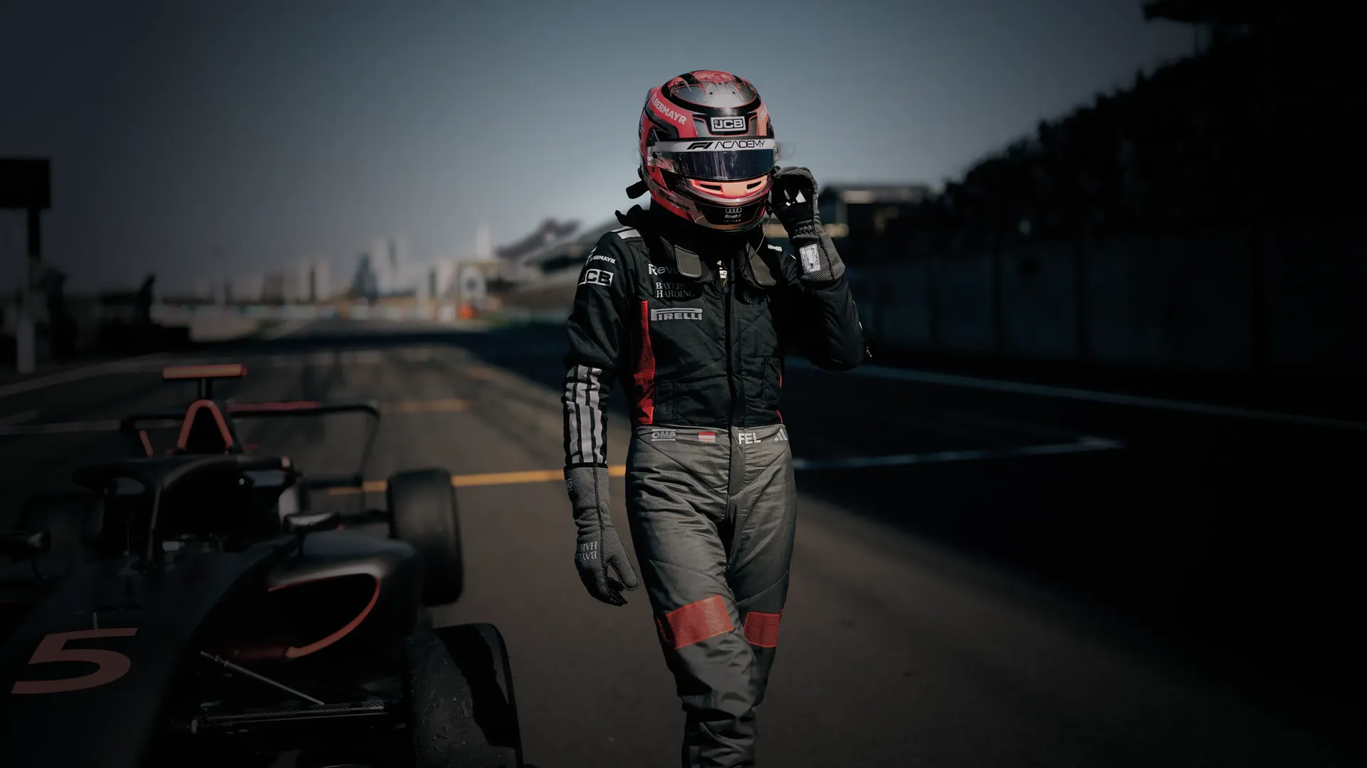 Driver Emma Felbermayr walking next to the Audi Revolut F1® Team Academy car on the racetrack Chinese Grand Prix at Shanghai