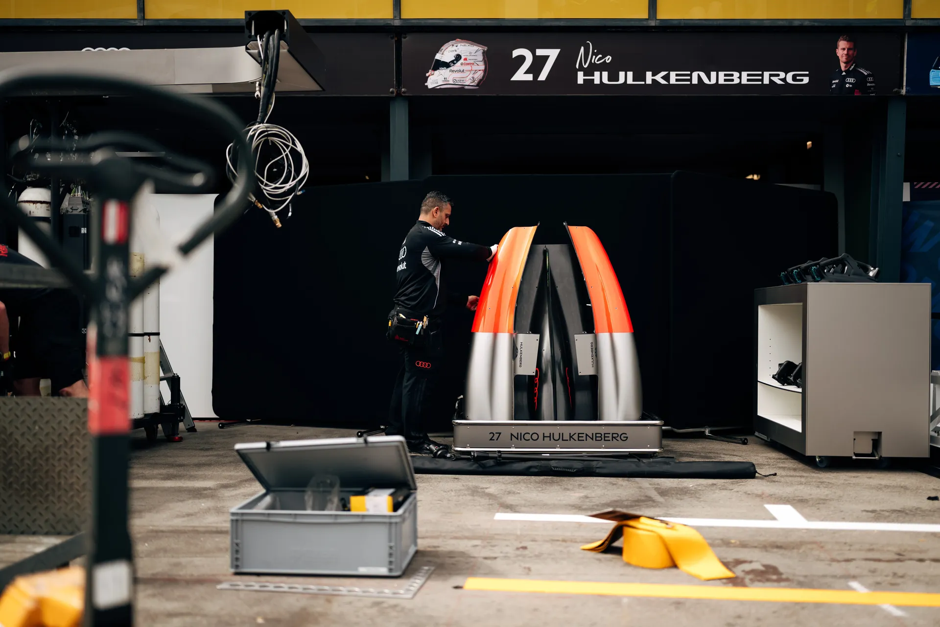 View in the box where the engine cover of Nico is and e team member is working on it