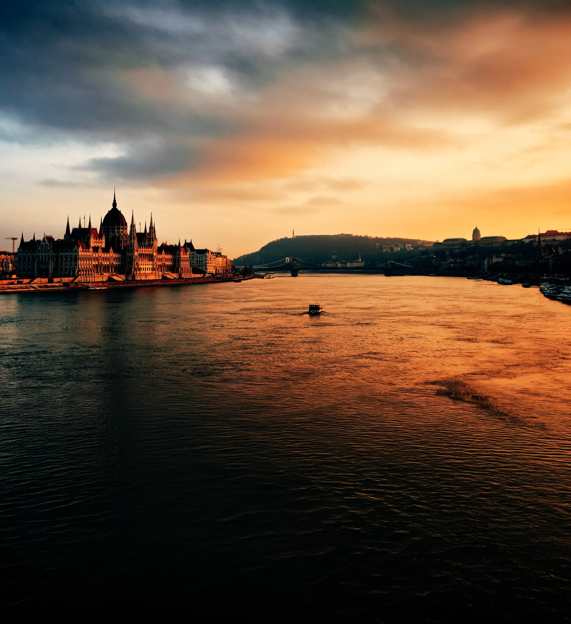 Sunset view across the Danube River with the Hungarian Parliament Building in Budapest.