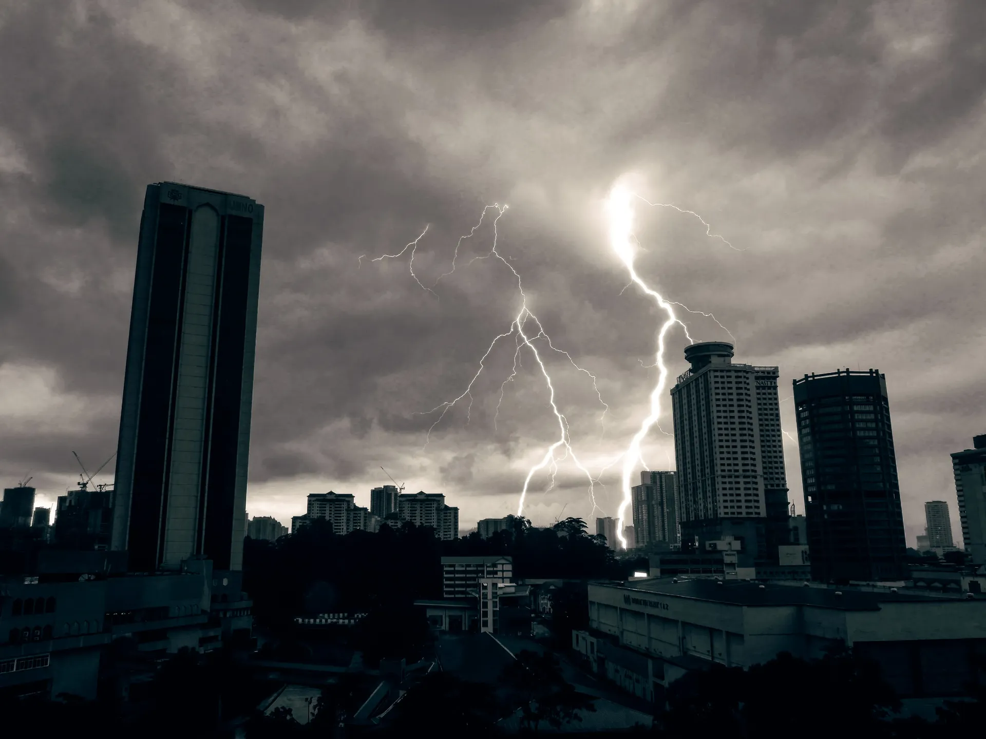 Kuala Lumpur skyline under dark storm clouds and lightning