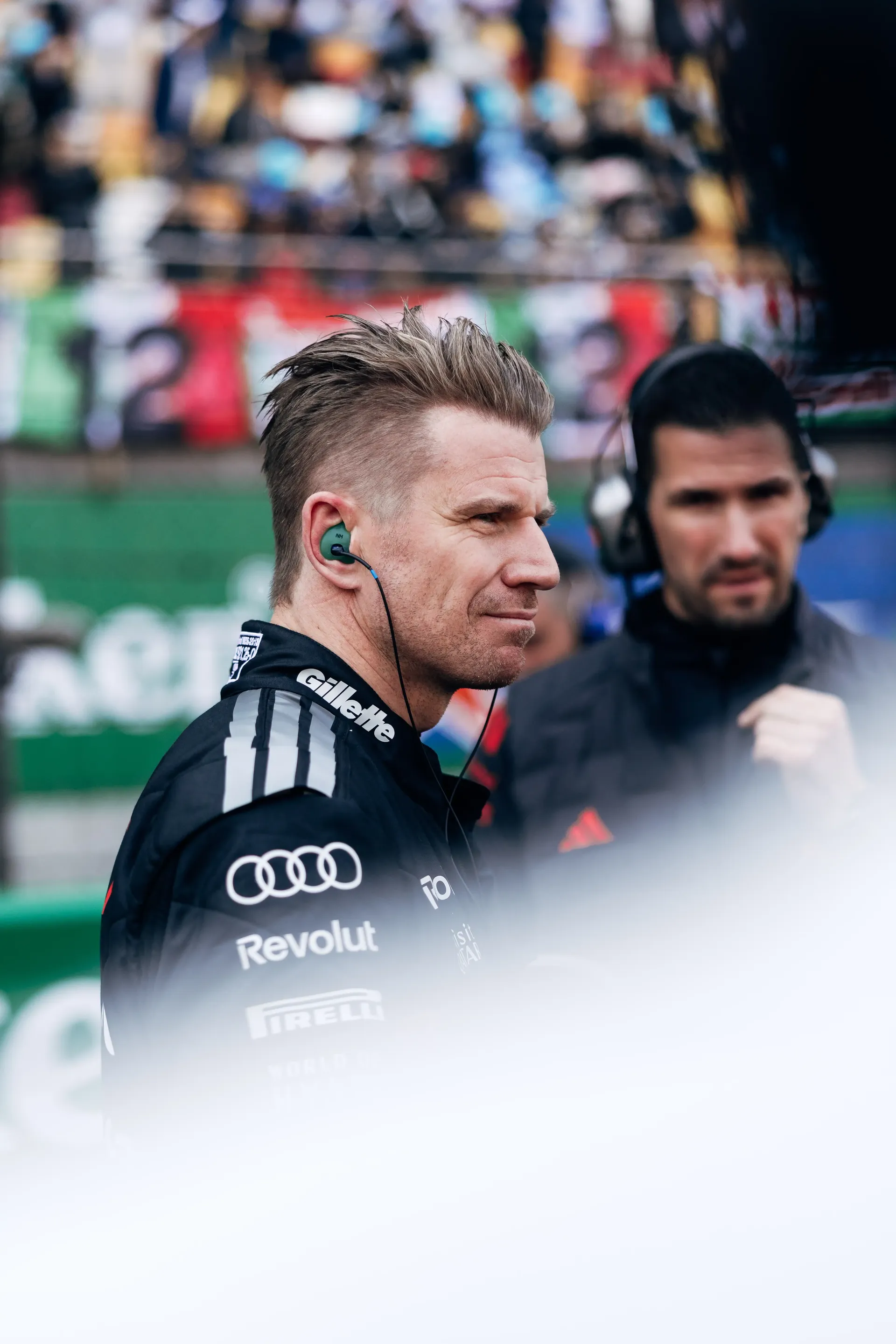 Nico Hulkenberg driver at the Audi Revolut F1® Team standing on the racetrack with crew mechanics