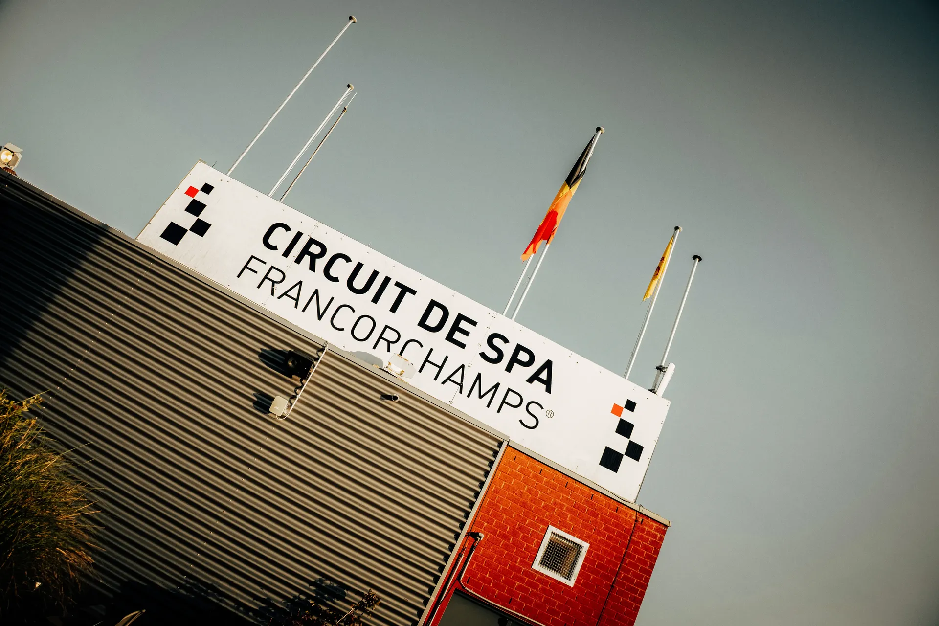 Exterior of the Circuit de Spa-Francorchamps building with the venue name displayed alongside national flags.