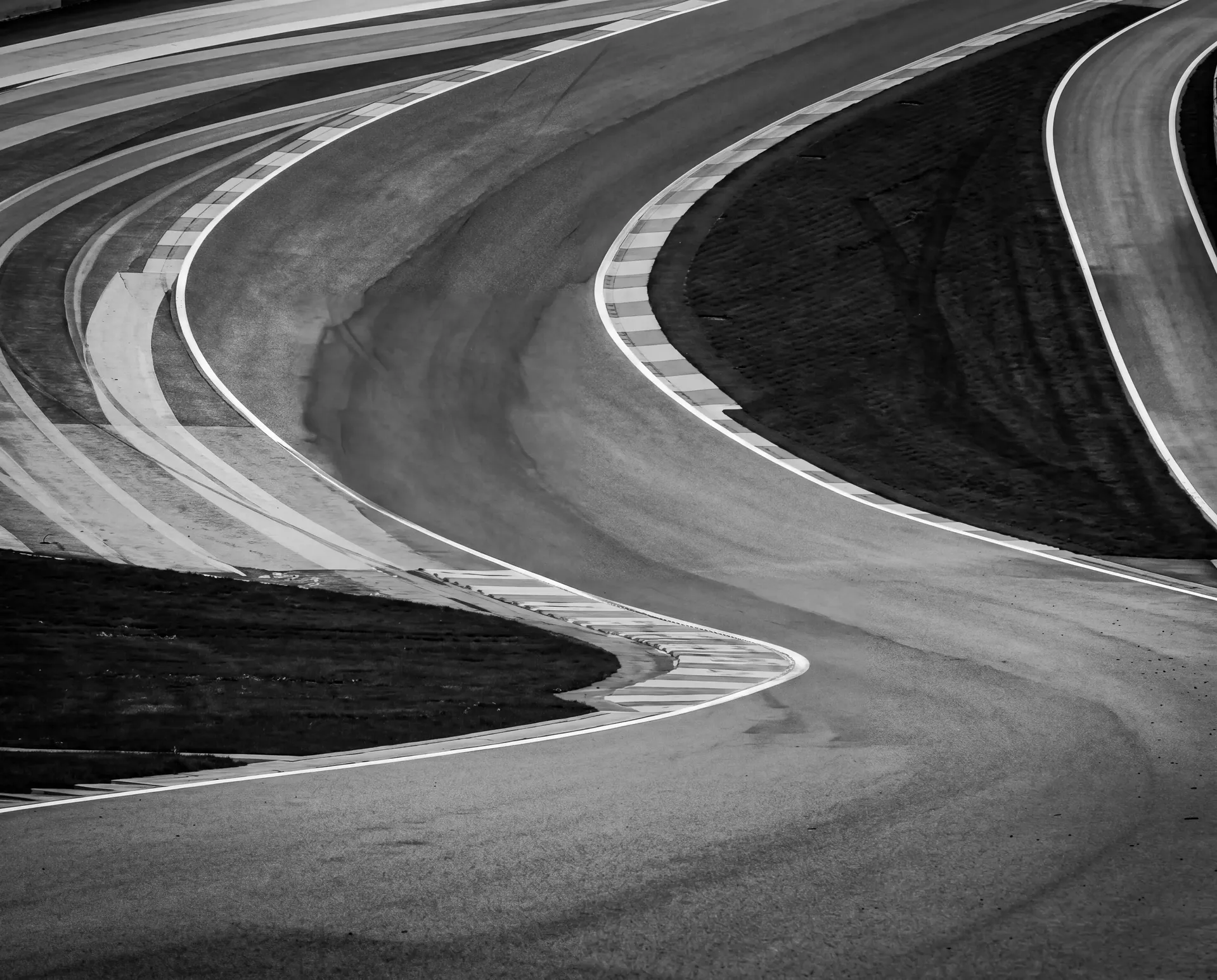 Black-and-white close-up of the Eau Rouge and Raidillon section showing the sweeping uphill curves of the circuit.