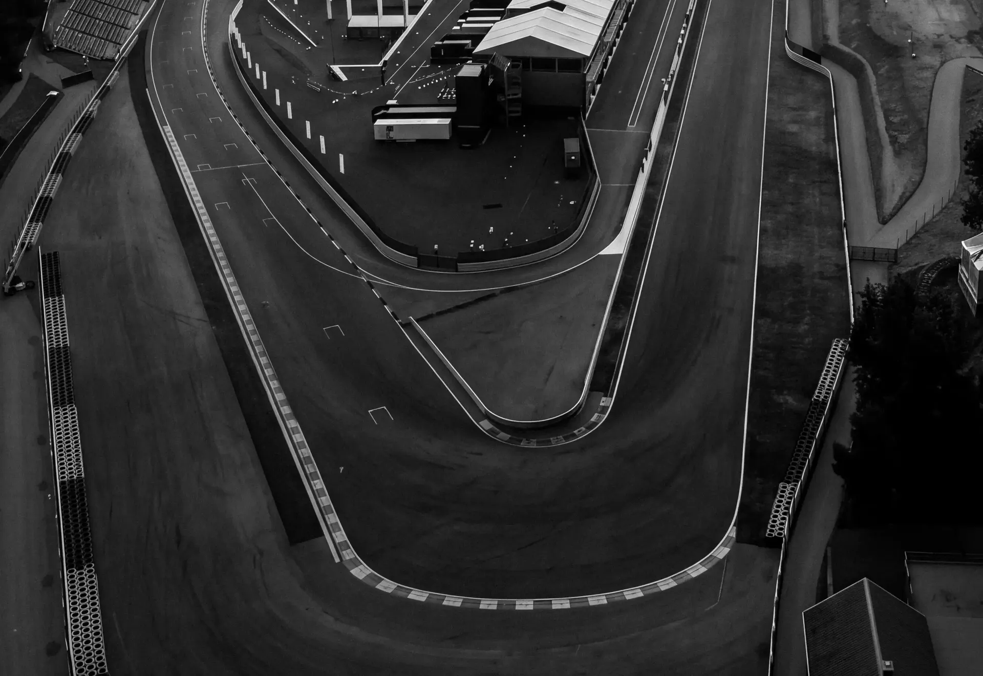 Black-and-white aerial view of the La Source hairpin and surrounding pit lane at Circuit de Spa-Francorchamps.