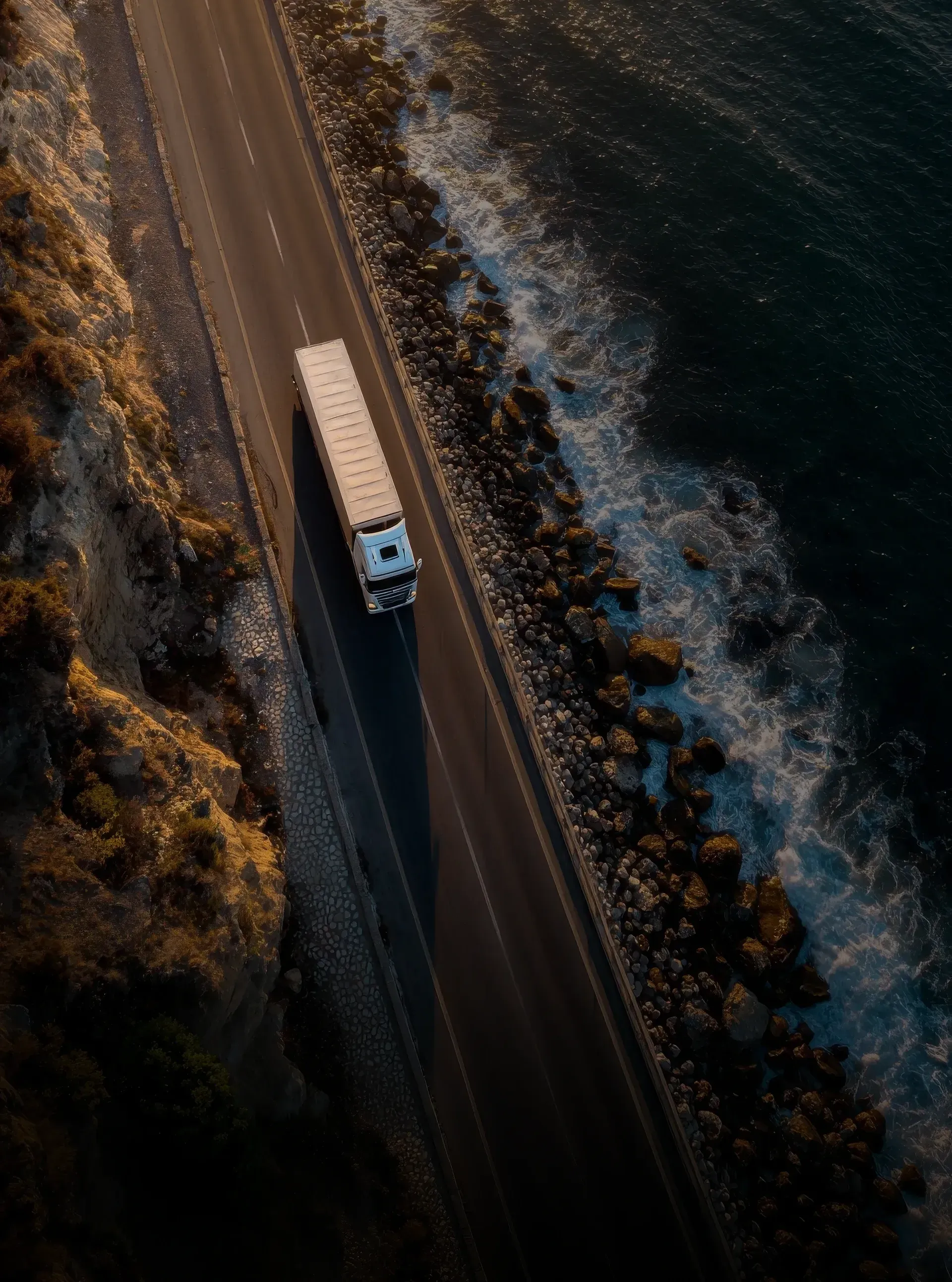 Aerial coastal highway shot of Audi Revolut F1® Team convoy traveling to Barcelona