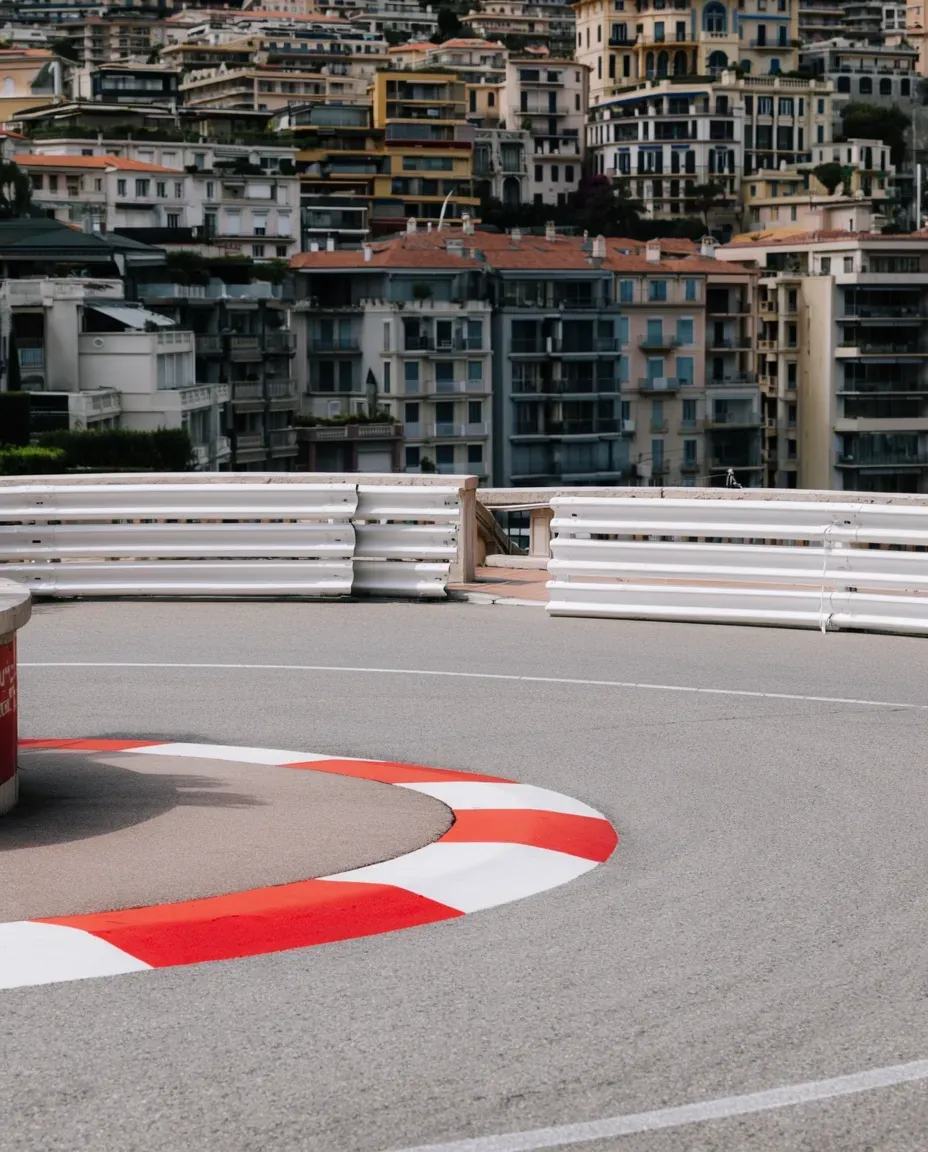 Elevated city view overlooking a winding Monaco road with distinctive red-and-white curbs.