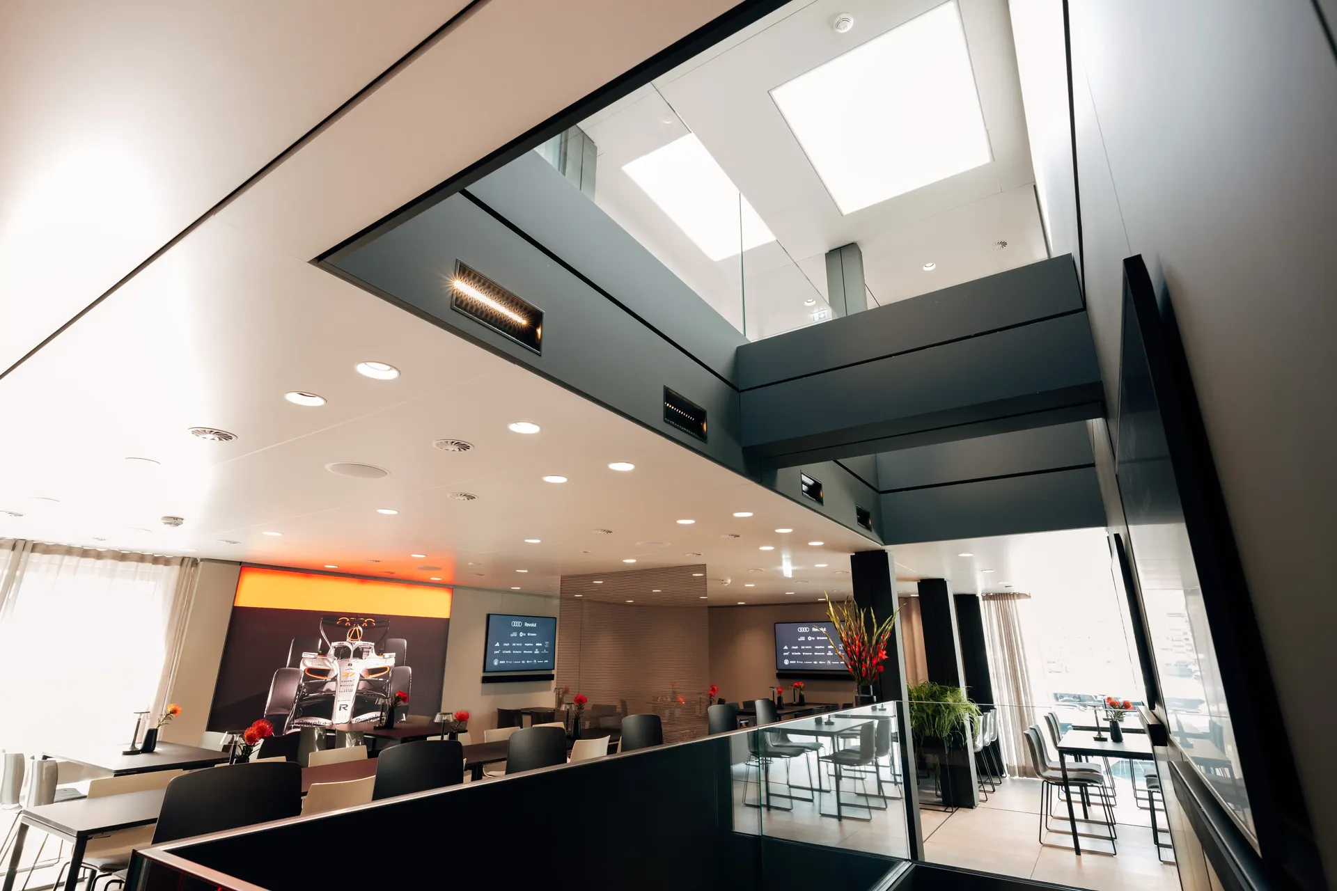 Interior view of the Audi Revolut F1® Team hospitality hub featuring a modern staircase and lounge area.
