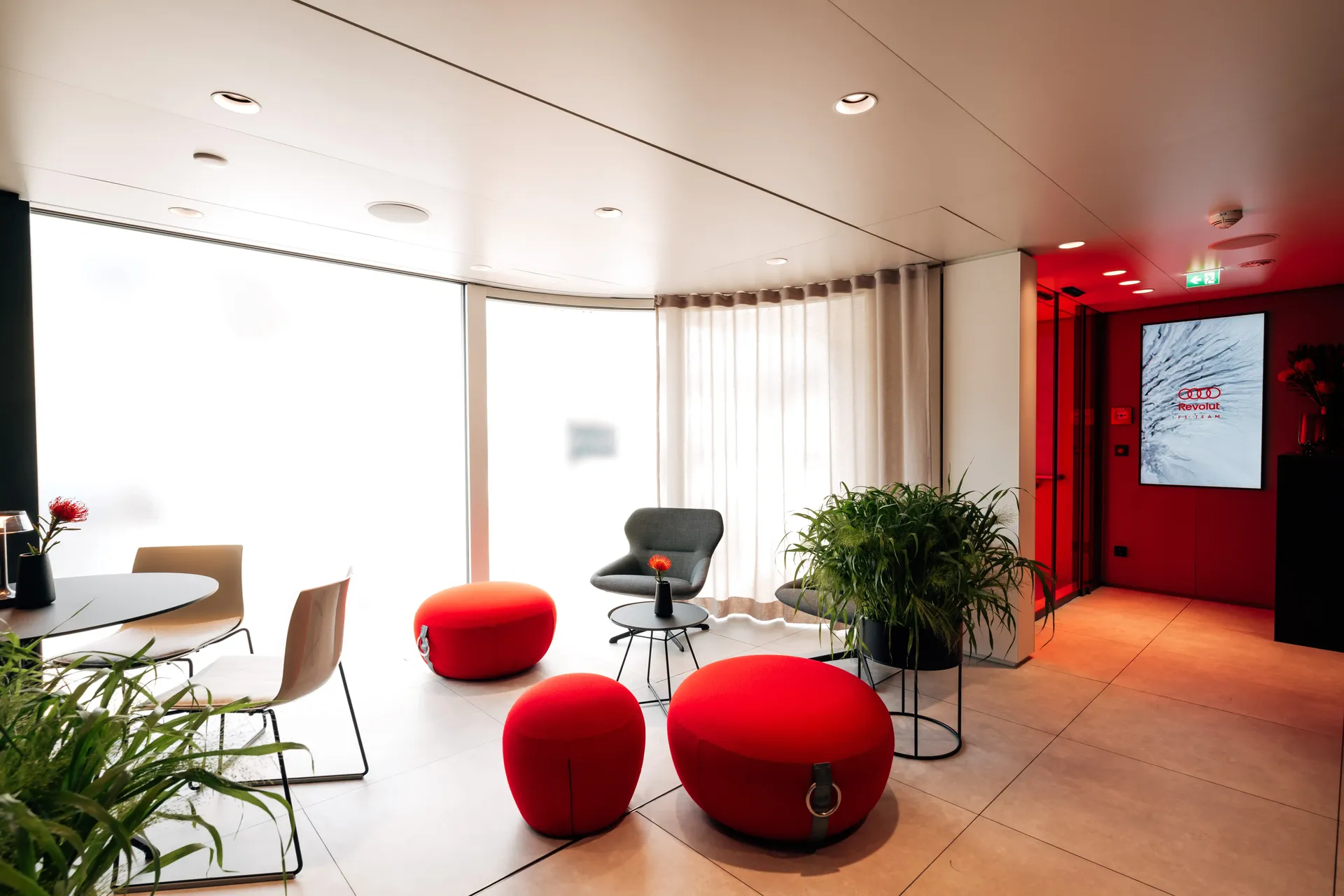 Hospitality hub interior featuring seating, tables, and Audi-branded design elements.