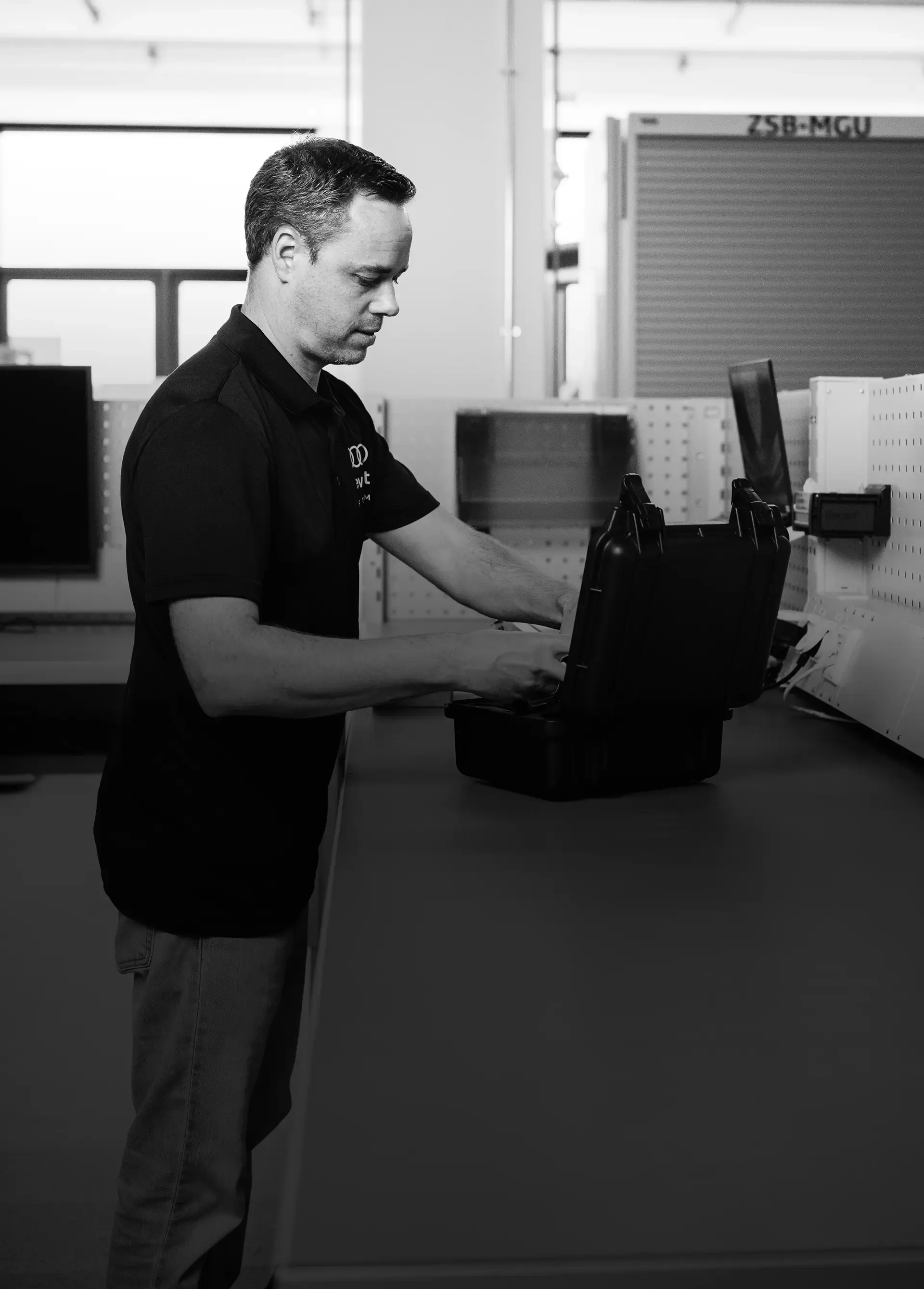 Black and white side shot of Audi Revolut F1® Team member inside his laboratory at work for the All for One Episode.