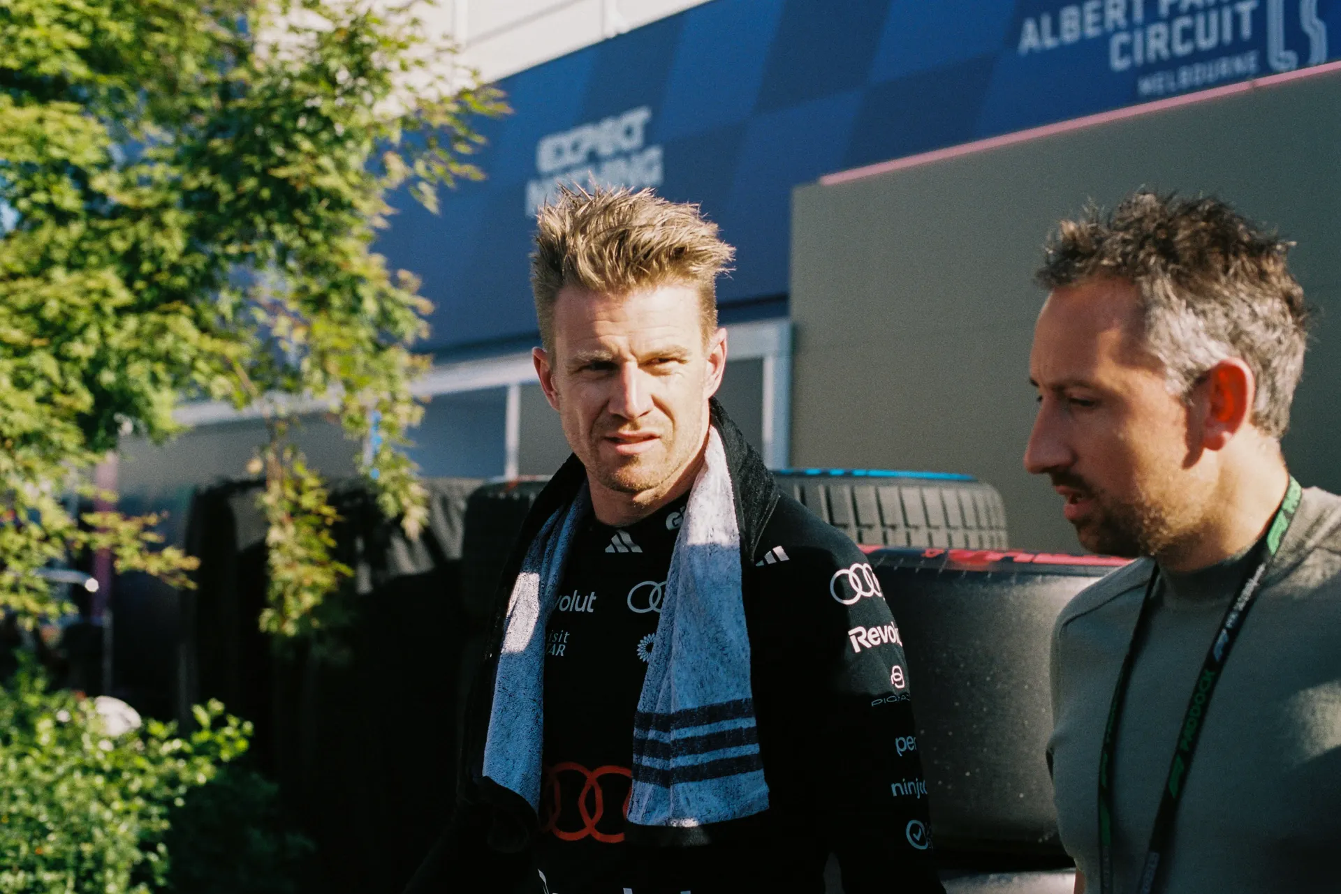 Audi Revolut F1® Team driver Nico Hülkenberg walks through the paddock alongside a team member.